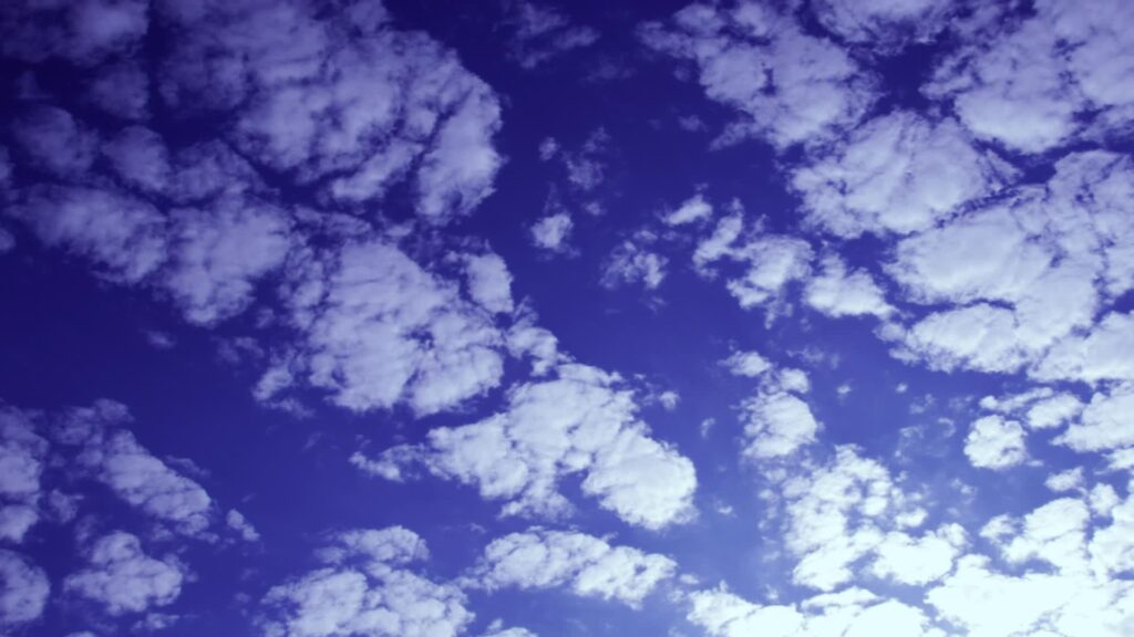 Time lapse of moving white clouds over vivid blue sky during sunrise or sunset