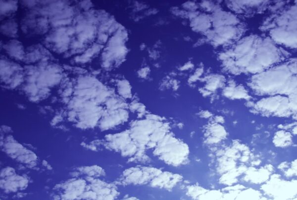 Time lapse of moving white clouds over vivid blue sky during sunrise or sunset