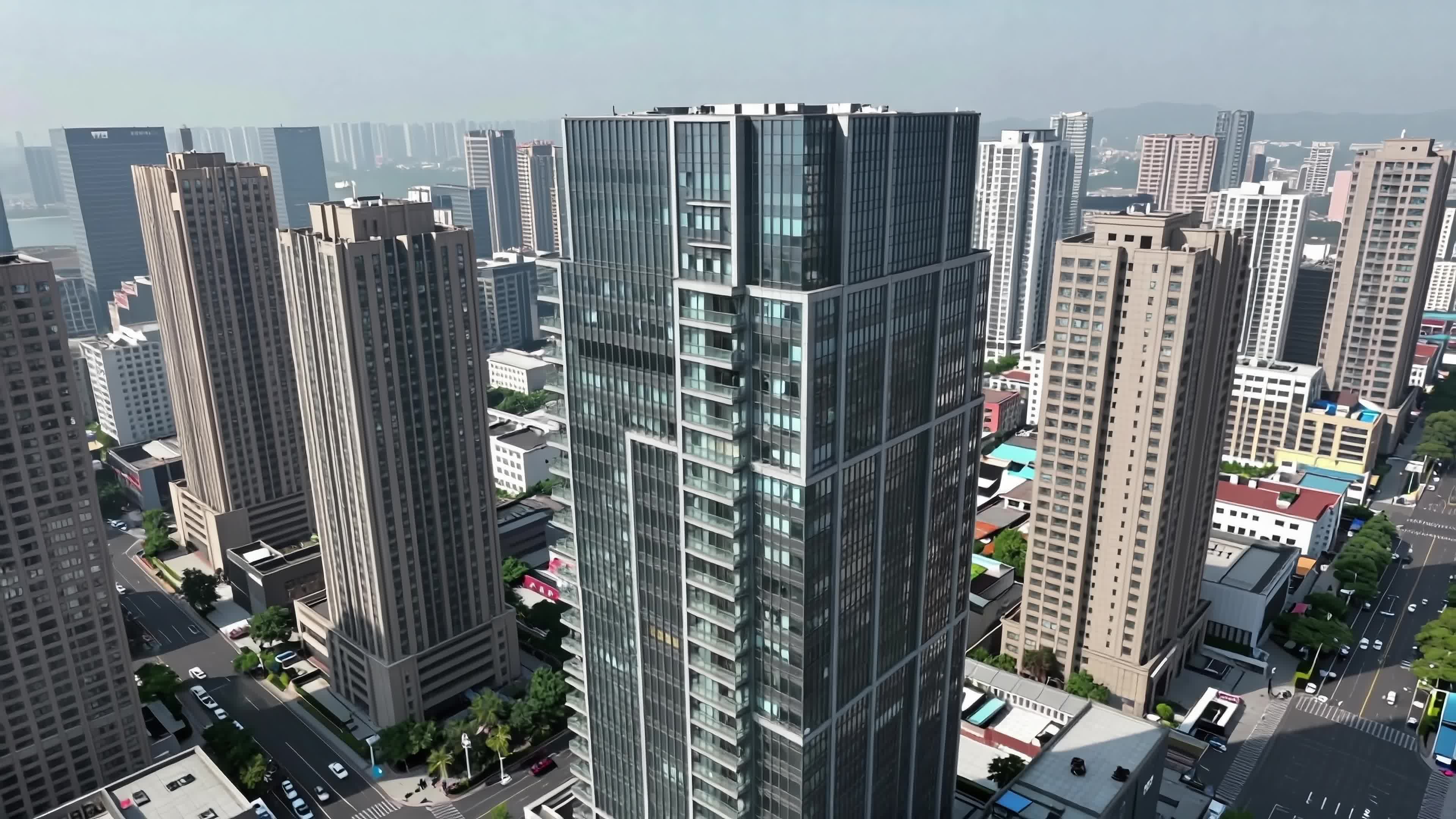 Modern city towers soaring against clear skies amidst bustling streets and mixed architecture - 4K video.