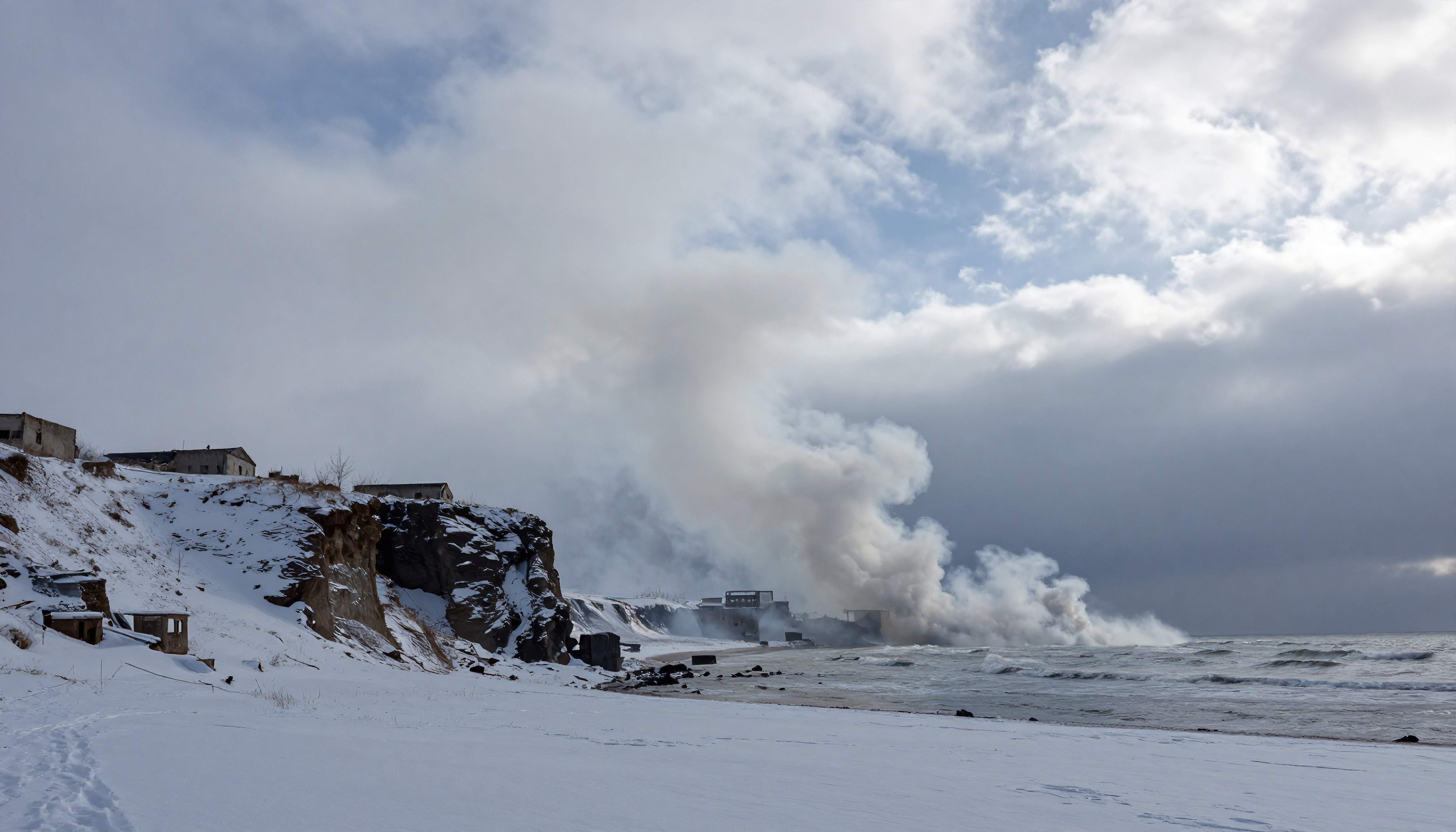 Snowy Coastal Cliffside with Abandoned Structures and Stormy Sea