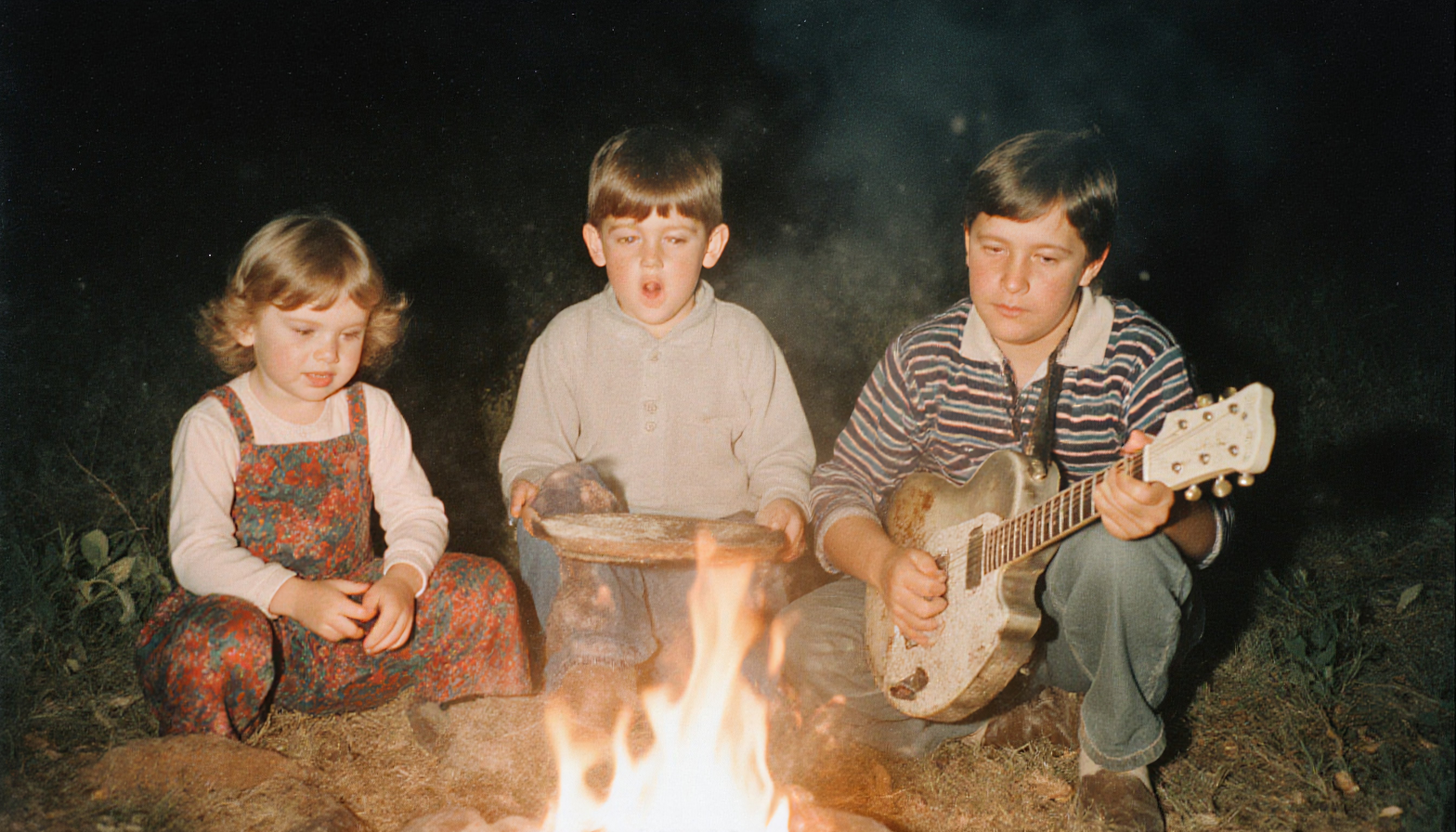 Children Around Campfire at Night: Nostalgic Outdoor Scene