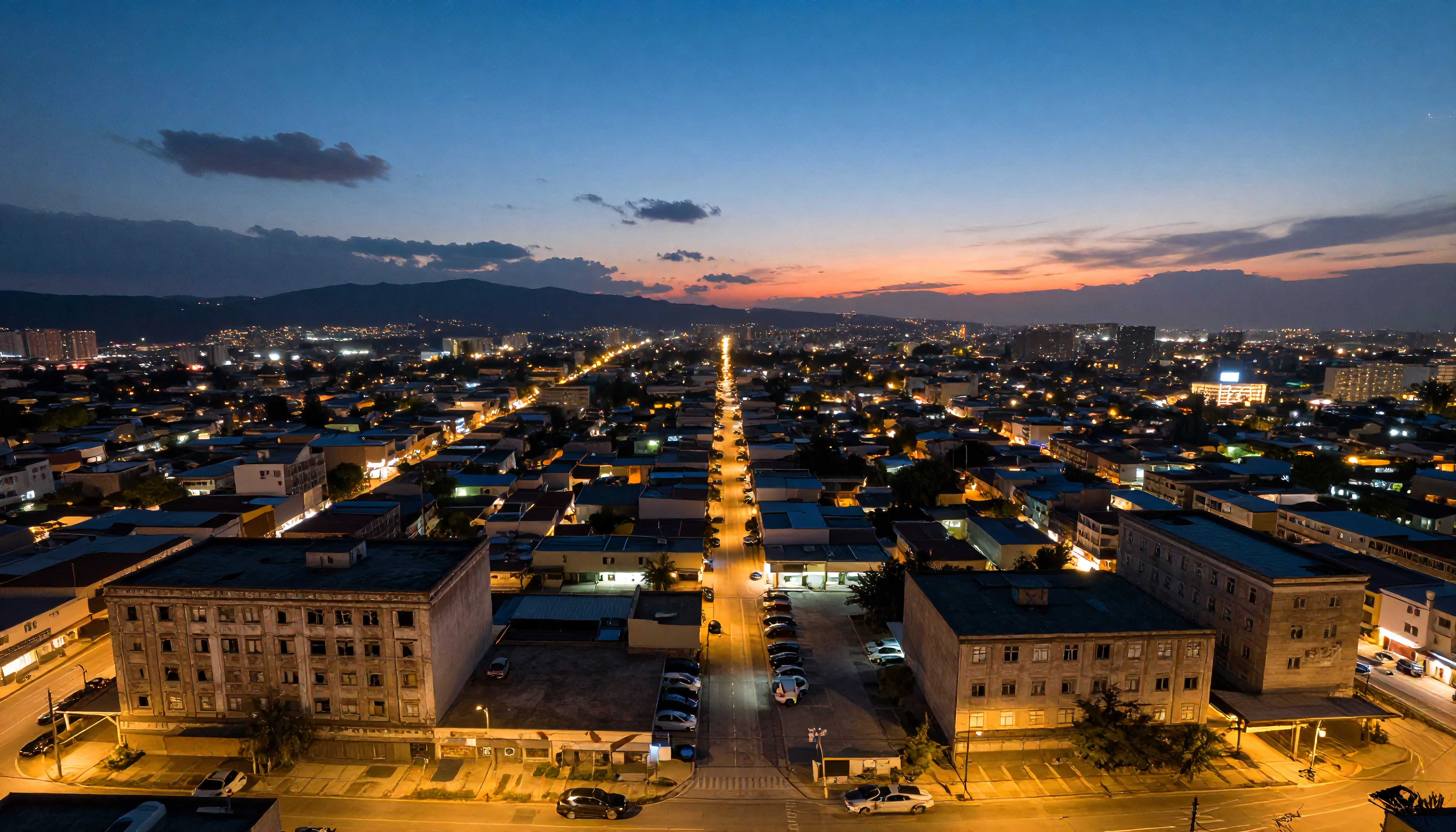 Aerial View of Urban Cityscape at Twilight with Sunset and Illuminated Streets