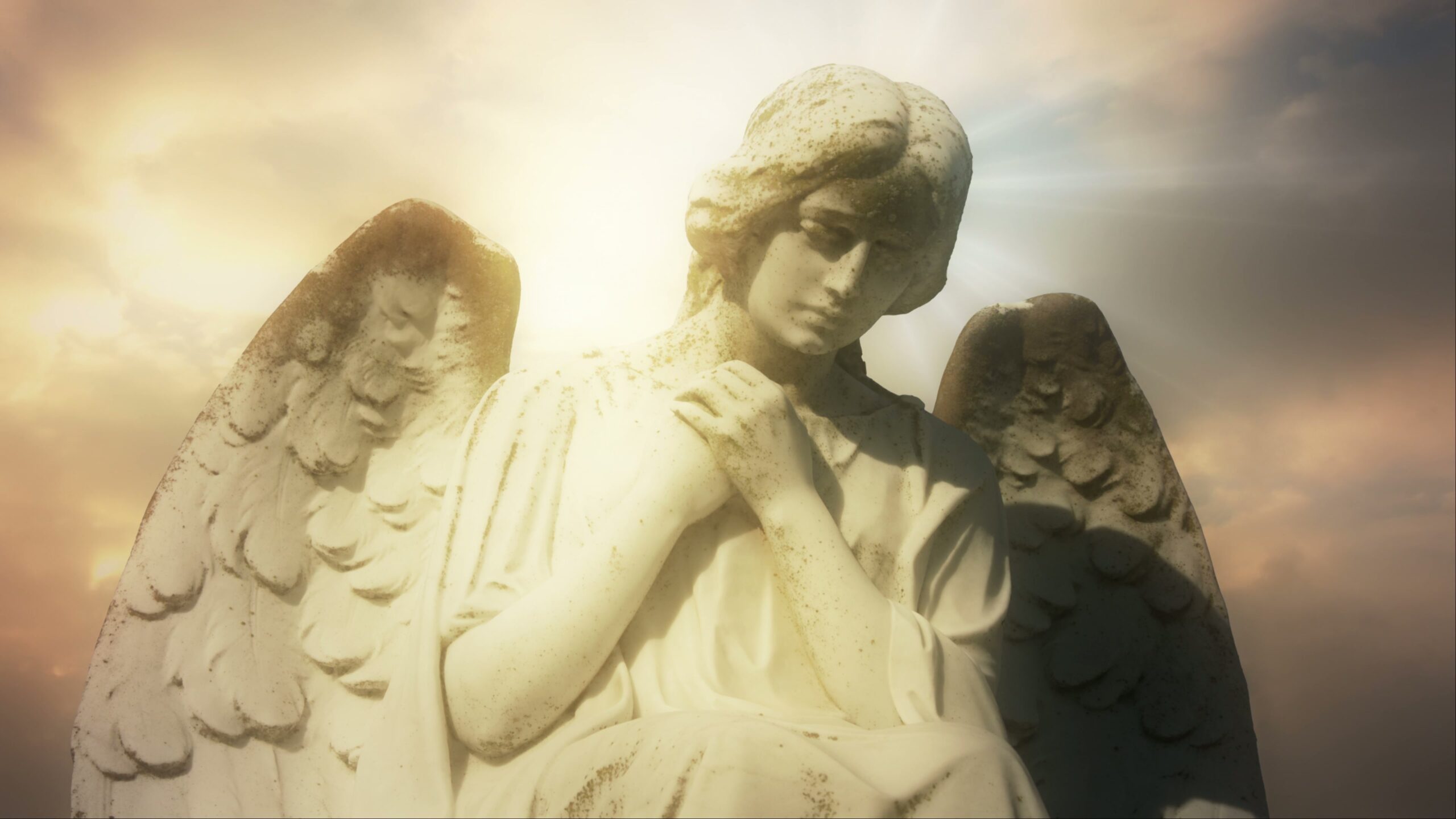 A serene angel statue with wings, bathed in golden light against a peaceful time-lapse sky backdrop.
