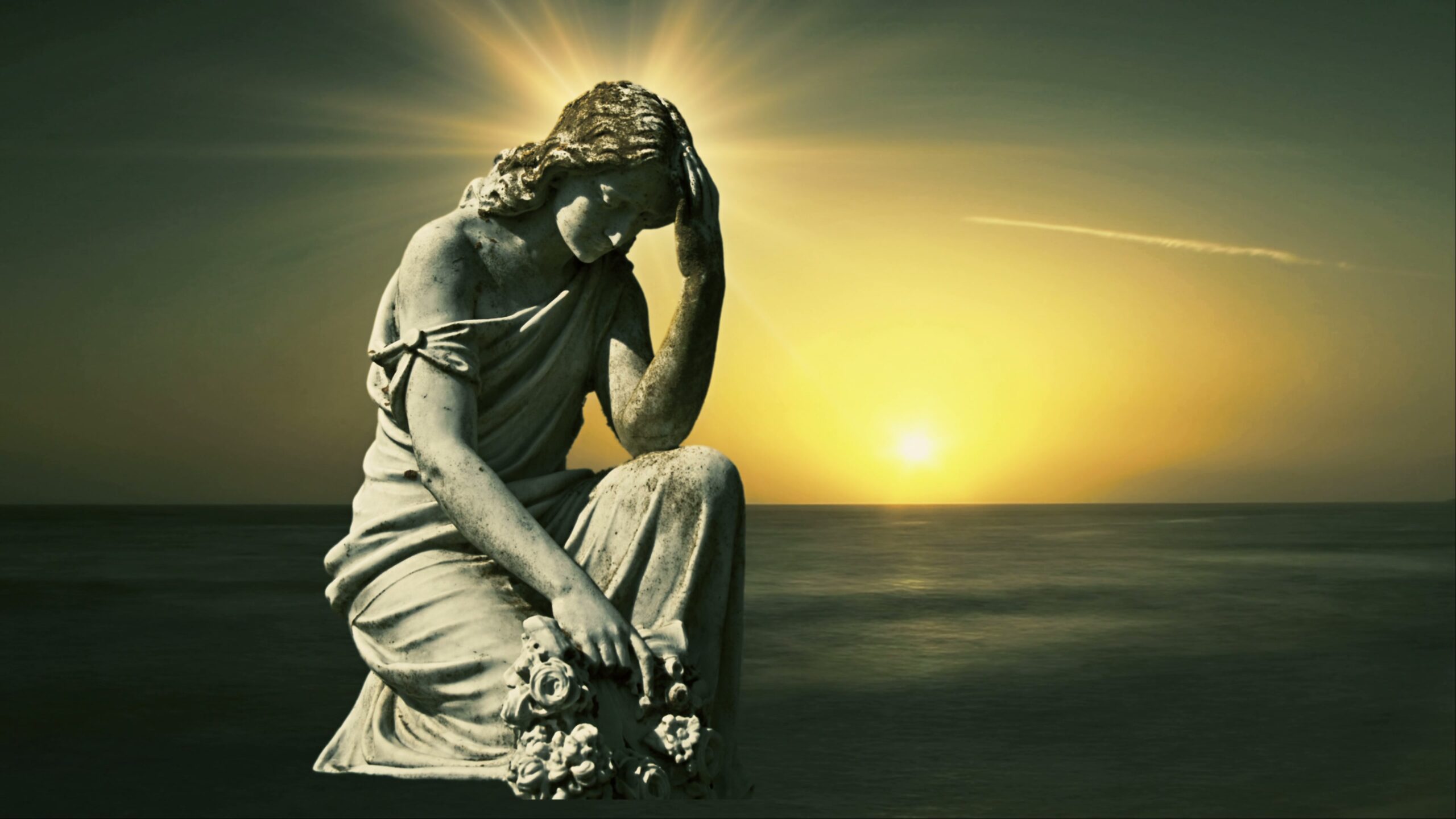 4K video of a serene statue on a golden time-lapse sunset over ocean evoking tranquility and reflection.
