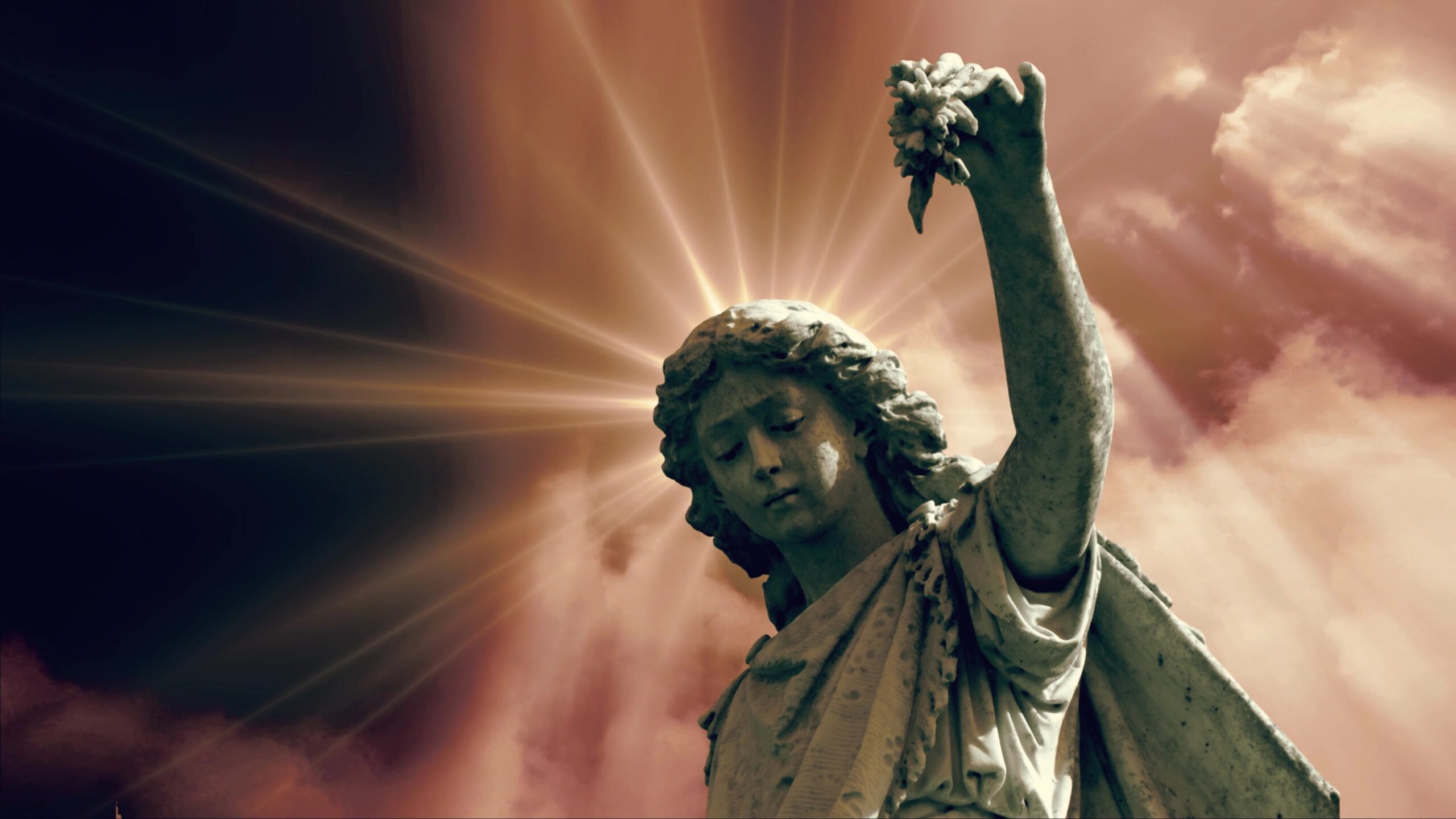 4K looping video of a stone angel statue with a radiant light burst background.