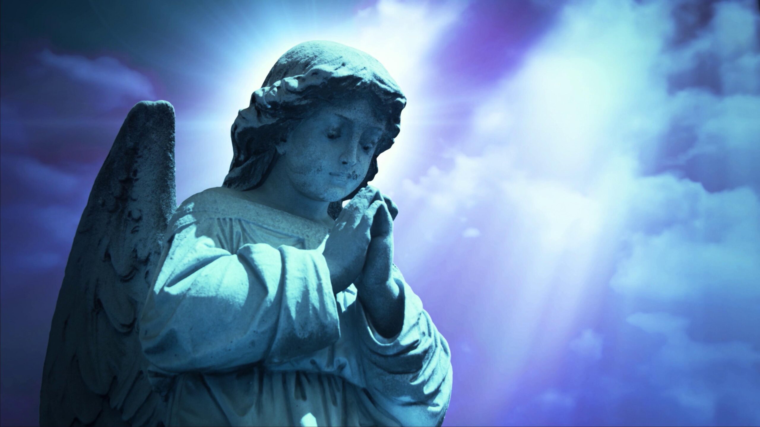 4K video loop of a serene stone angel statue bathed in blue light, praying amidst a luminous time-lapse sky, evoking peace and spirituality.
