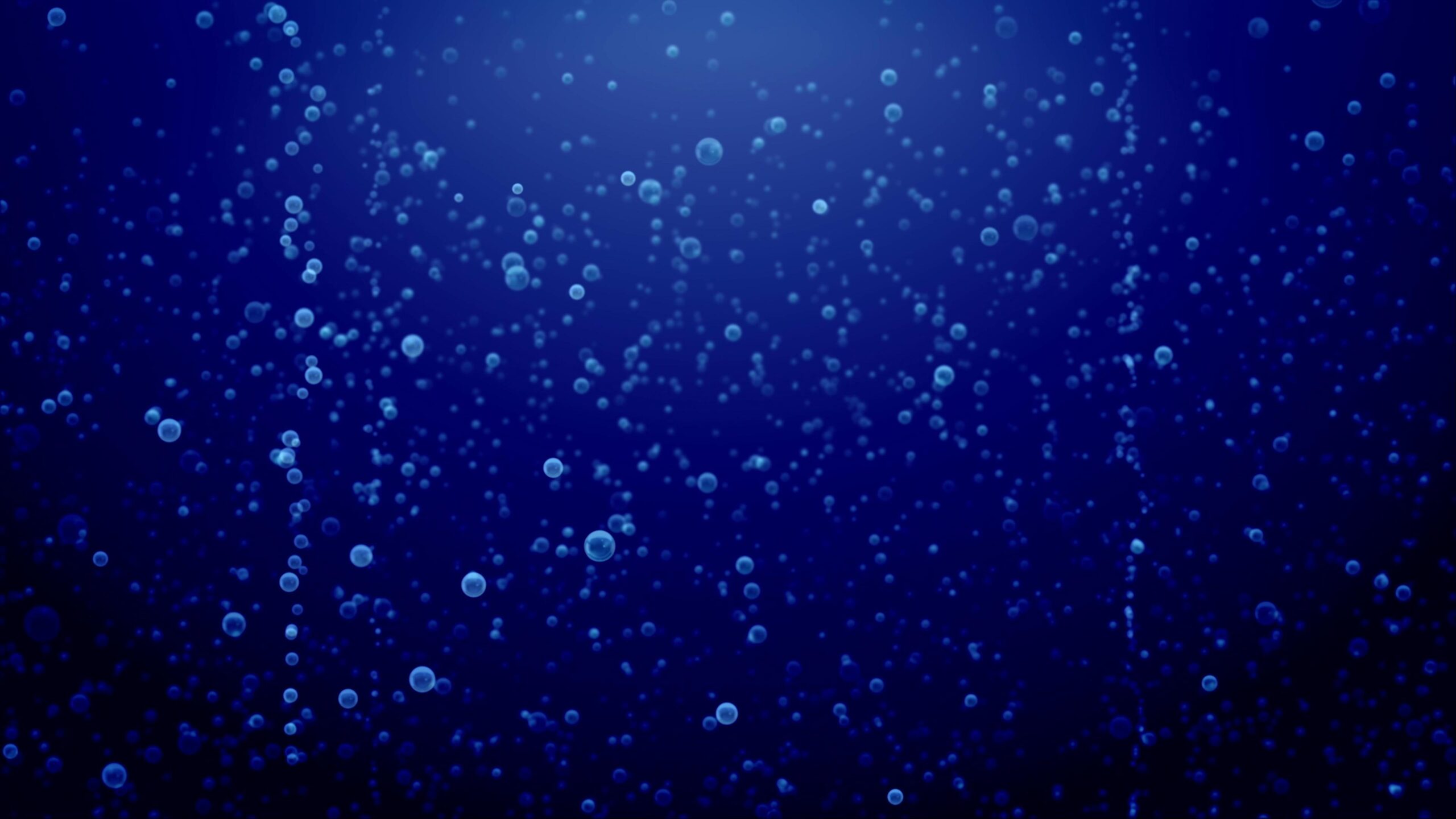 Floating Bubbles Illuminated Against Dark Blue Background