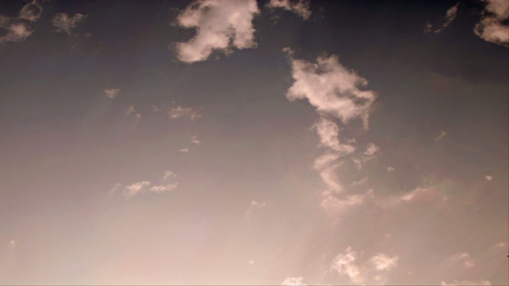 A tranquil time-lapse sky during sunrise or sunset with wispy clouds and a pink-purple gradient, evoking a peaceful and serene atmosphere.