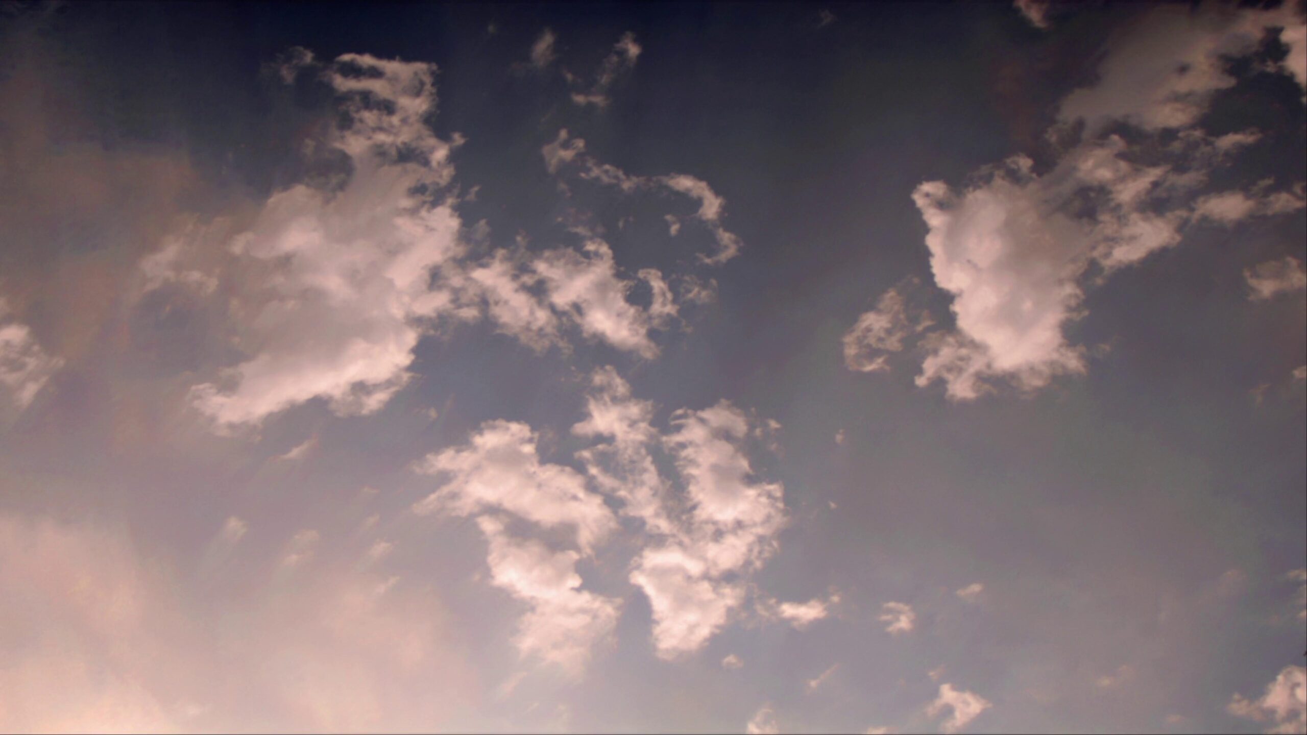 4K video of a serene sunset sky with wispy time-lapse clouds and a warm gradient.