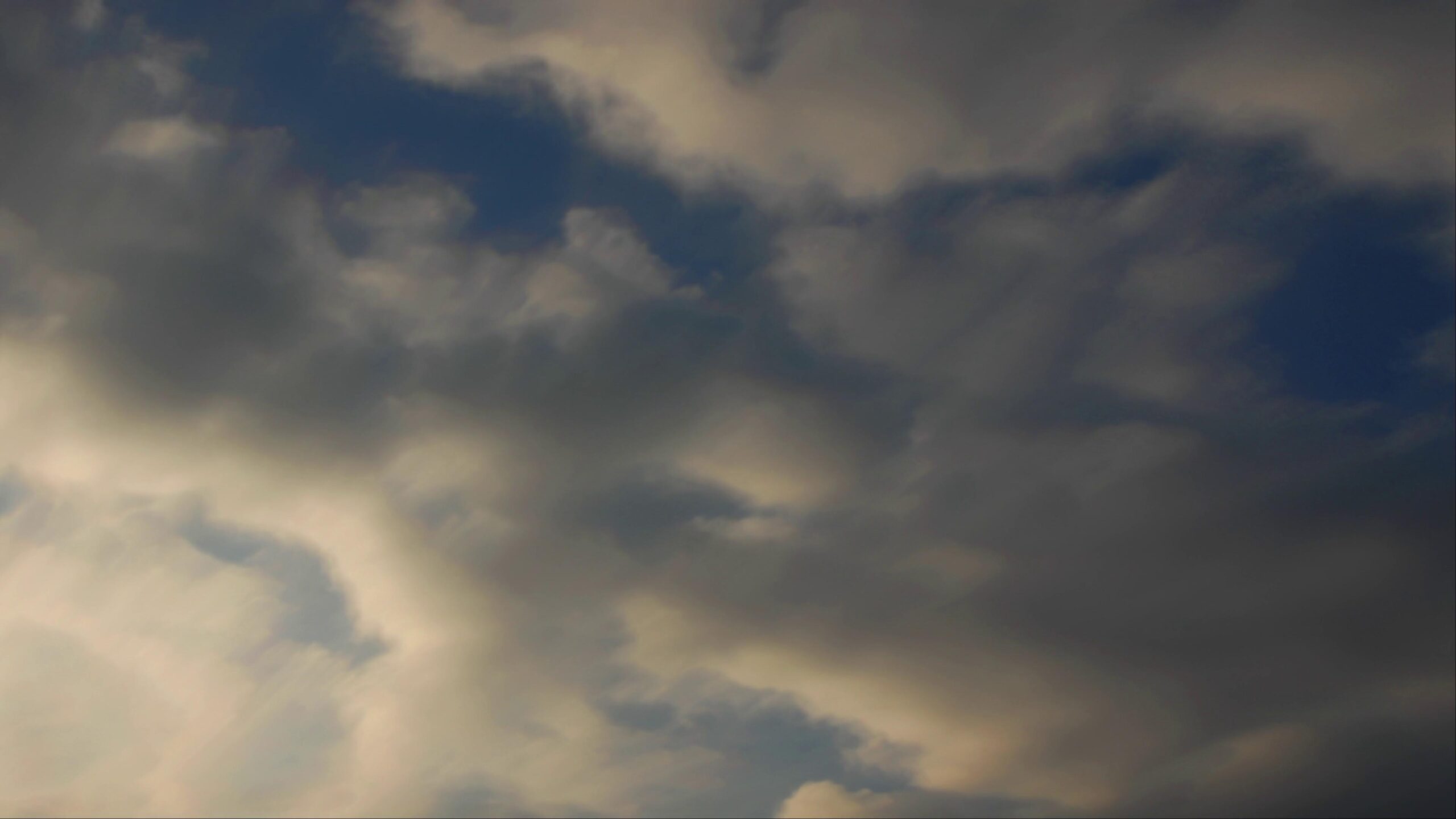 4K video of a dark evening sky filled with thick, moody time-lapse clouds.