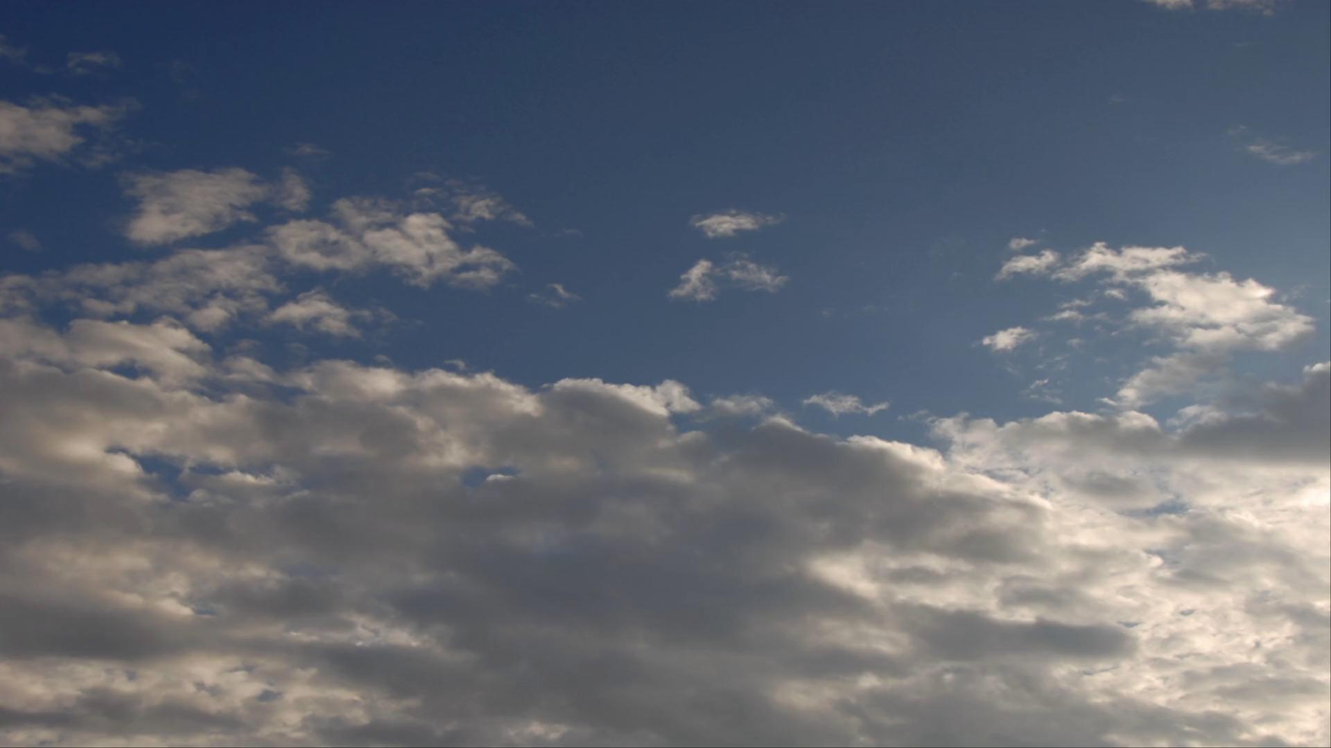 A tranquil sky with a gradient of blue and scattered wispy time-lapse clouds, creating a serene and peaceful atmosphere.