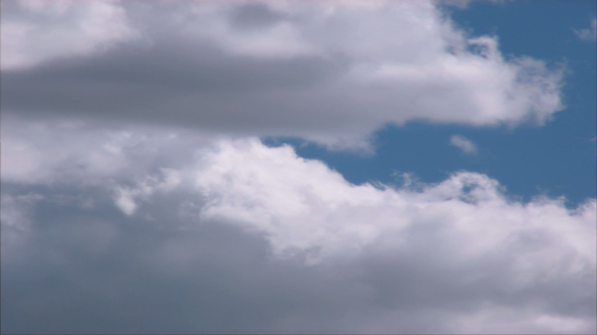 A captivating view of dynamic time-lapse clouds set against a vibrant blue sky, showcasing contrasting light and dark areas, emphasizing the beauty and complexity of natural weather patterns.