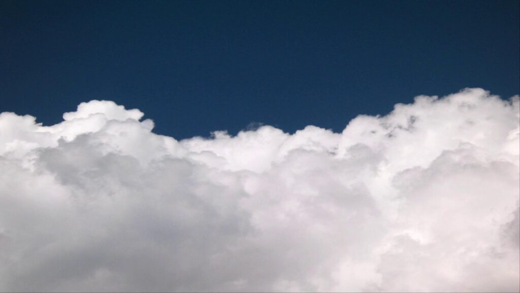 HD video timelapse of drifting white clouds over dark blue sky