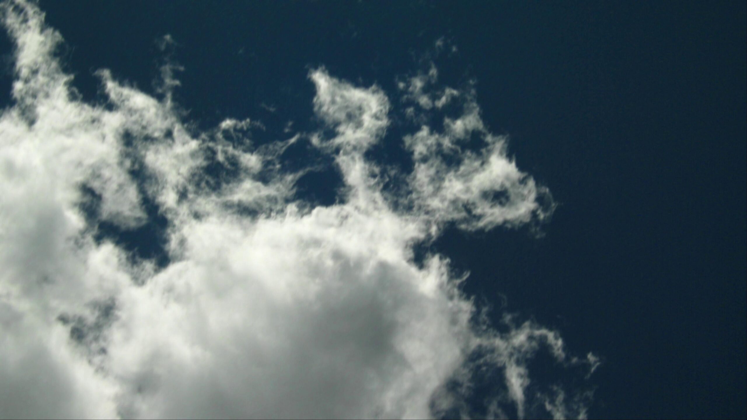 A vast expanse of darkening sky transitioning from bright time-lapse clouds to twilight shadows.