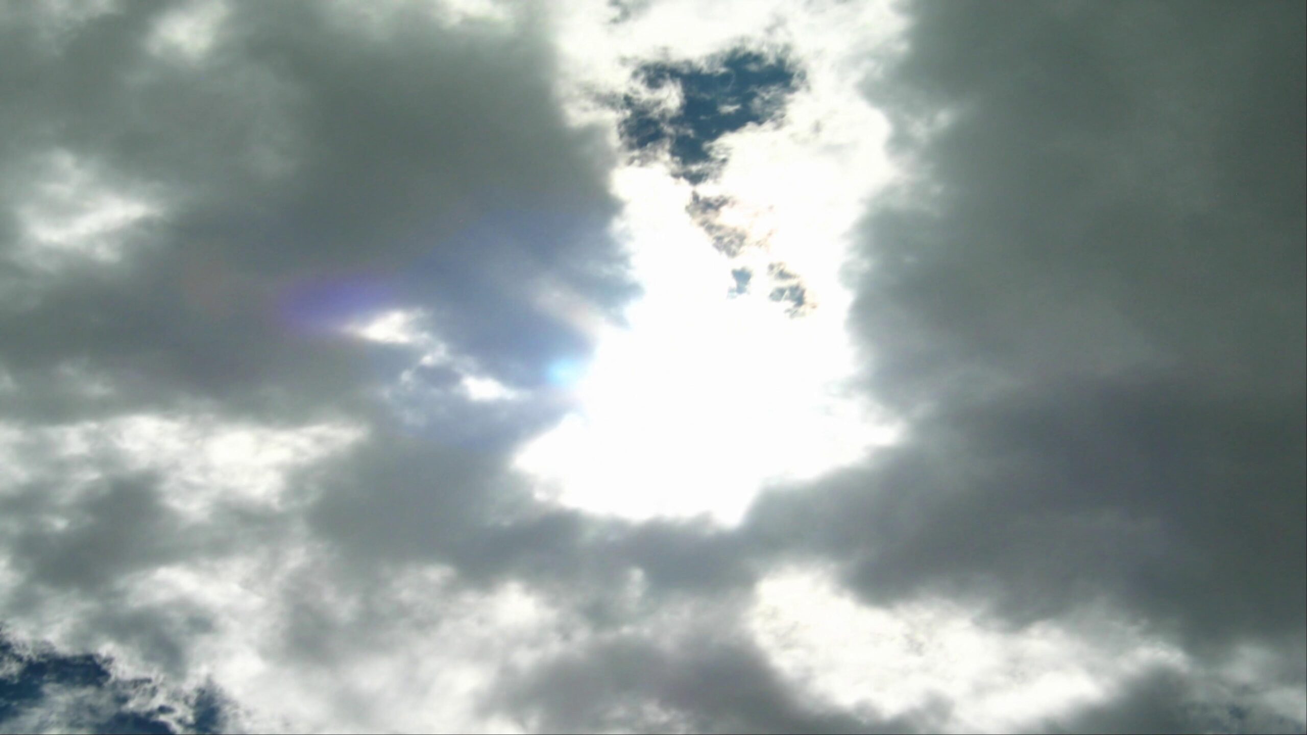 Bright sun shines through scattered time-lapse clouds.