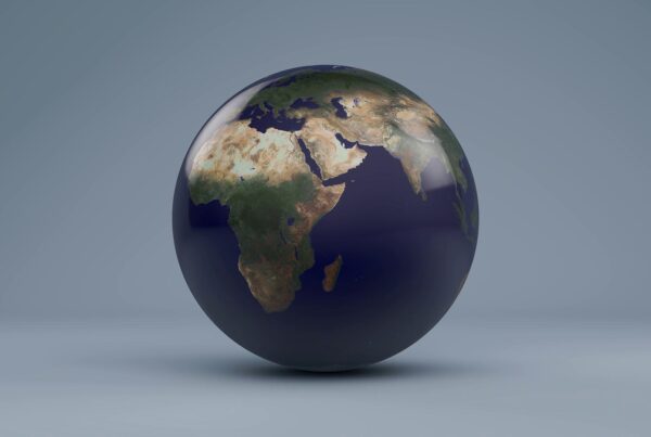 High-resolution rotating earth model with realistic textures and shadows set against soft gray-blue backdrop.