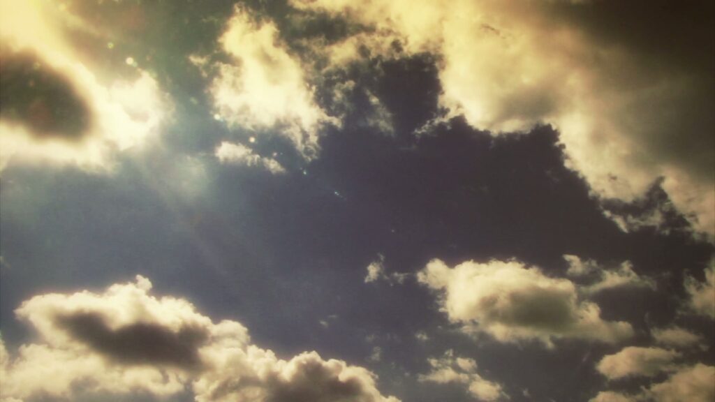 The video is a captivating view of time-lapse clouds, some white and others with a hint of gray, float across the screen.