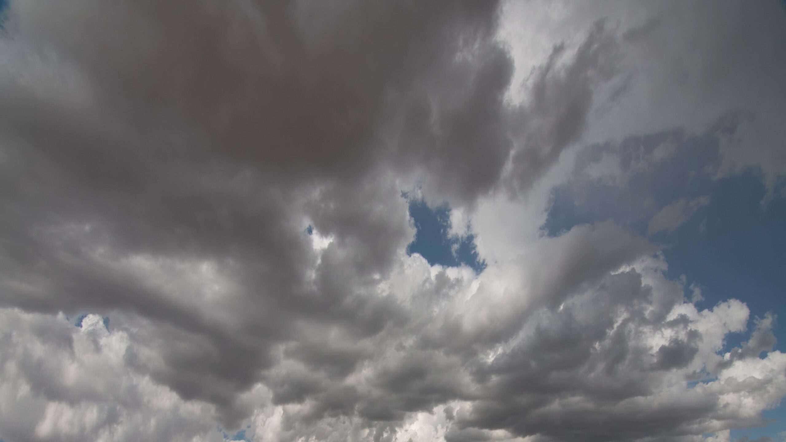 Dramatic storm clouds moving quickly over deep blue skies