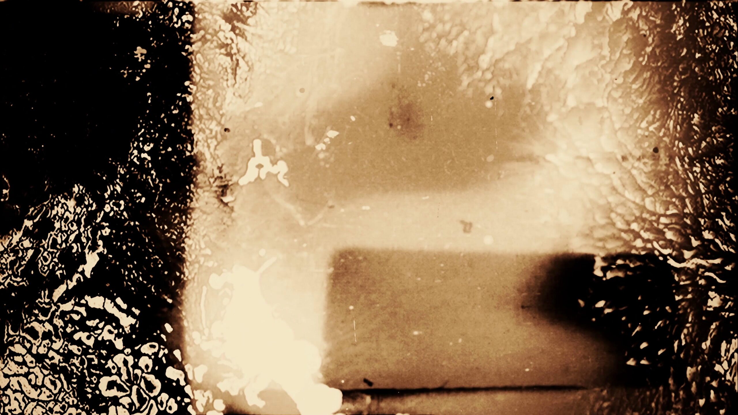 4K video loop of damaged 16mm film with scratches, specks, and warmth-toned shadows.
