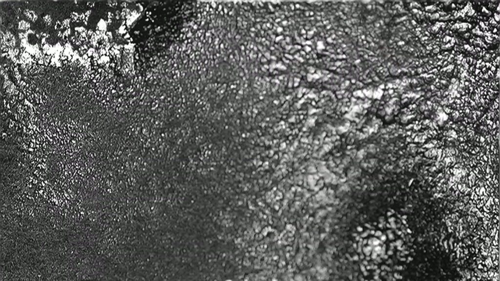 A high-contrast black and white abstract video animation featuring flickering film damage.