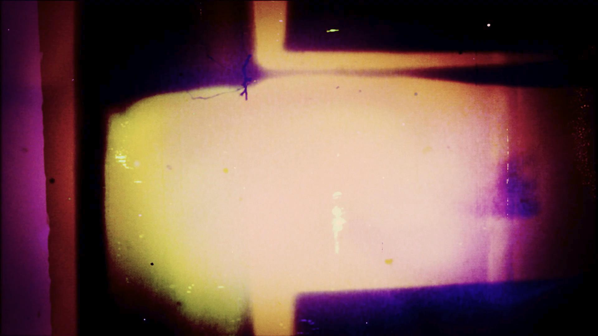 HD video loop of a vibrant, abstract visual featuring glowing yellow and purple hues against a dark backdrop.