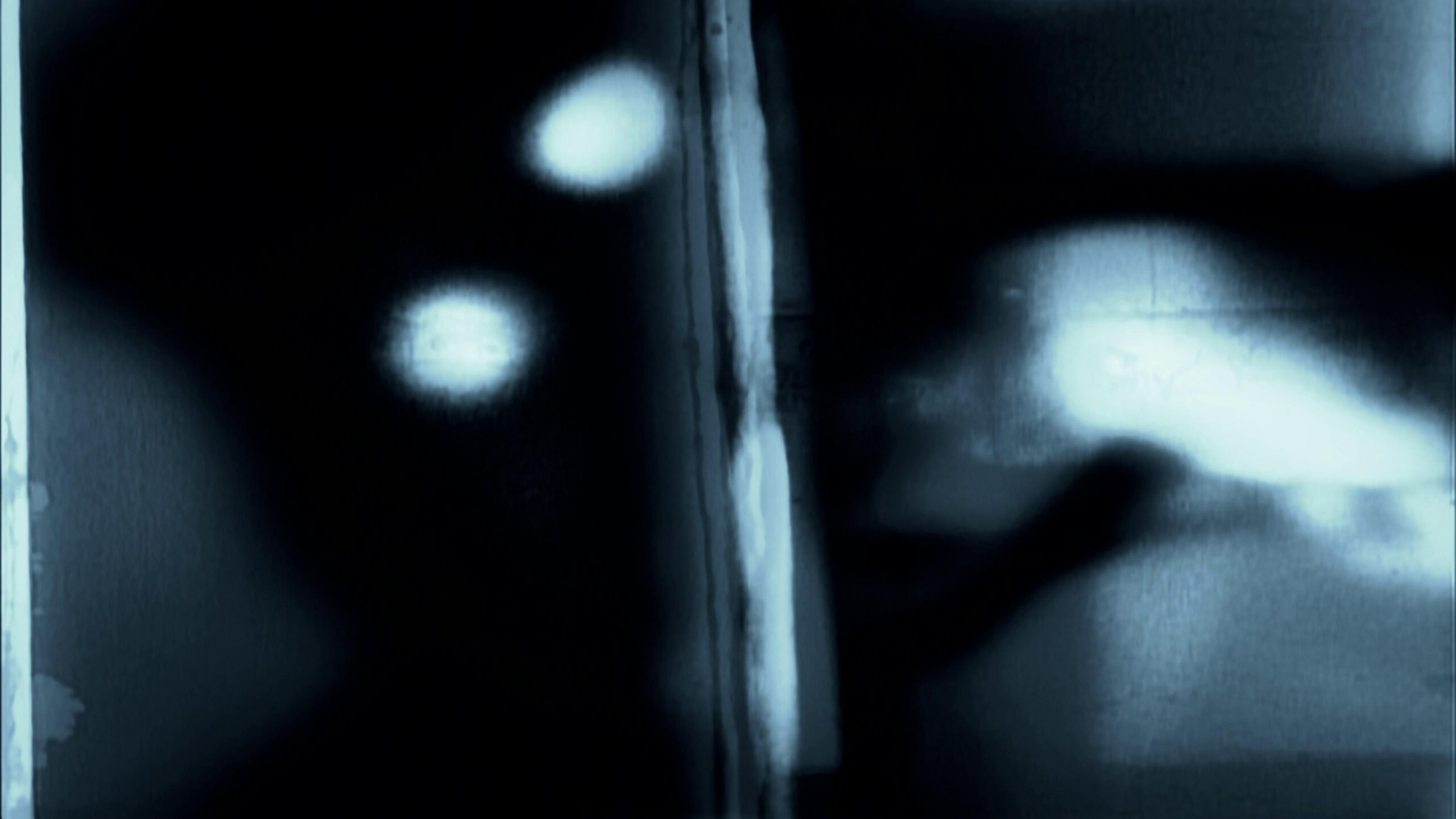 Abstract 4K video loop of 16mm film grainy blur with ghostly blue tones and subtle motion effects.