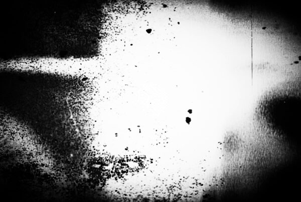 4K looping video of black-and-white film leader with specks, vertical lines, floating circles, and faint light streaks — retro glitch effect ideal for dark themes or atmospheric backgrounds.