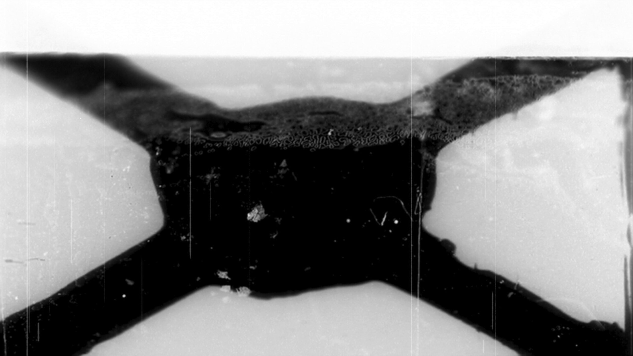 4k video of grainy 16mm film leader with scratches and dust spots