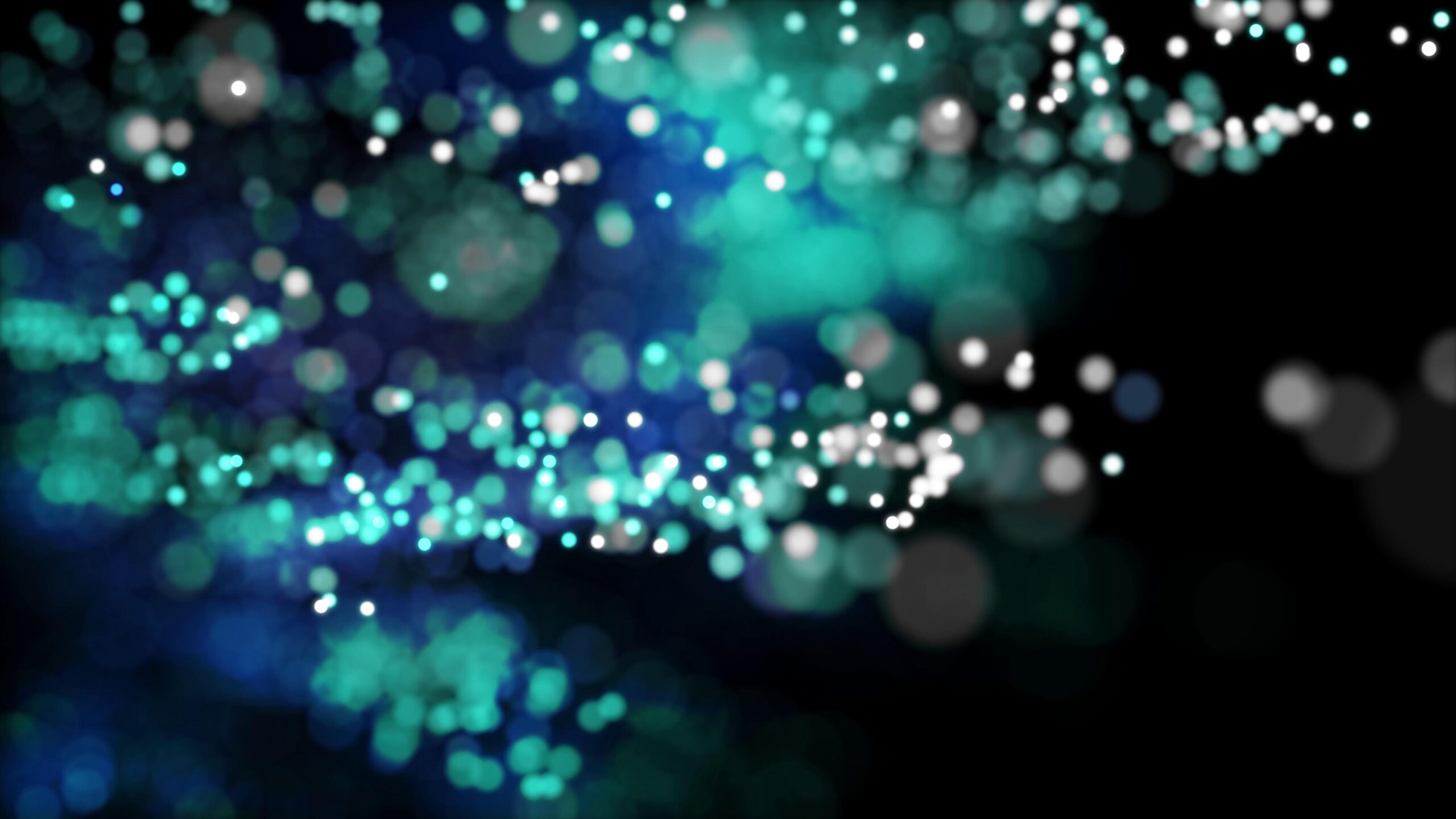 4K looping video of glowing teal-blue particles floating against dark background