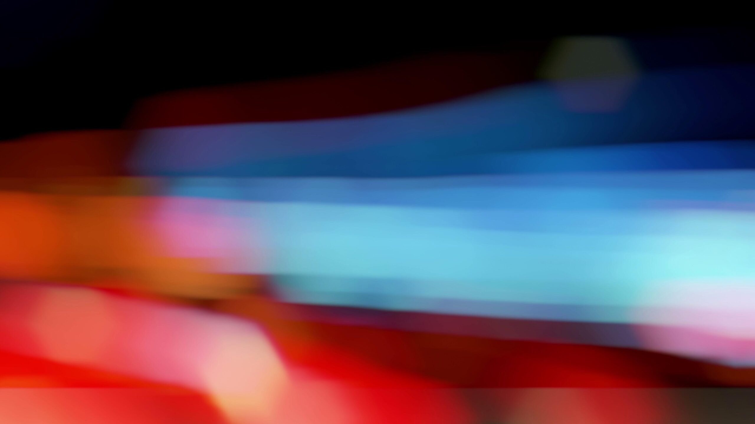 Abstract neon streaks blur night streets.