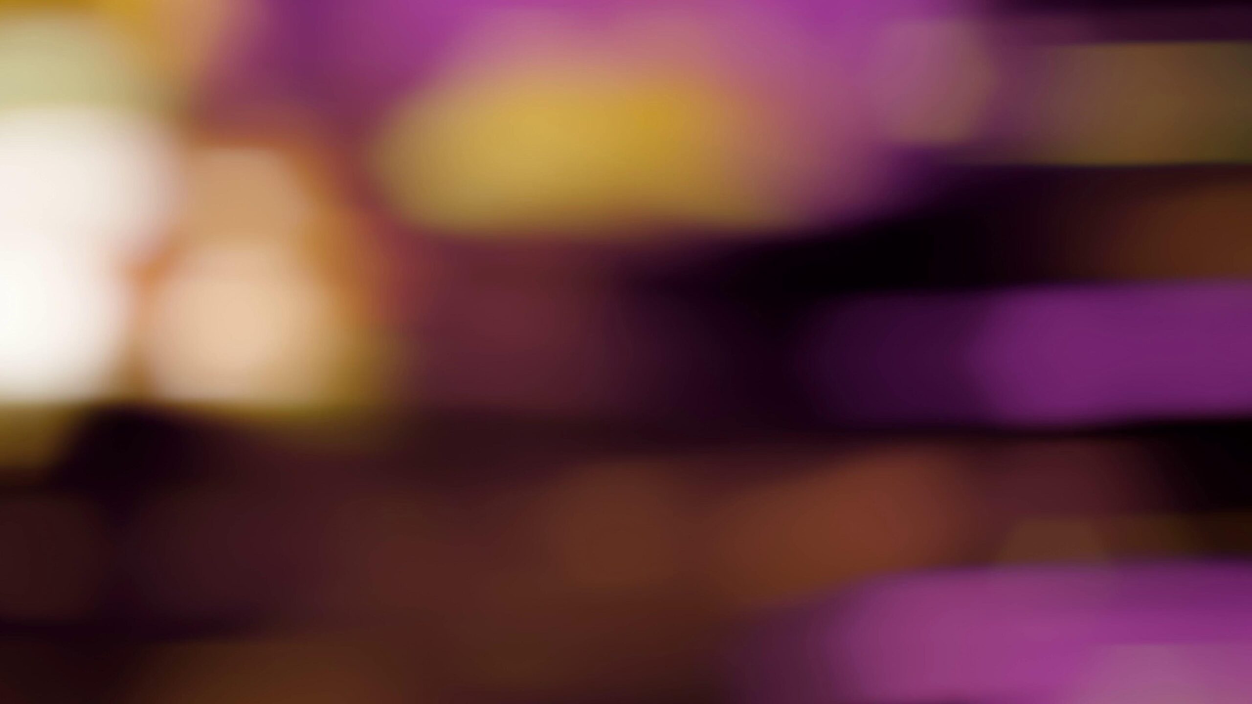 Colorful abstract 4K video loop with hexagonal bokeh and vibrant blurred lights in shades of pink, purple, and yellow on a dark background.