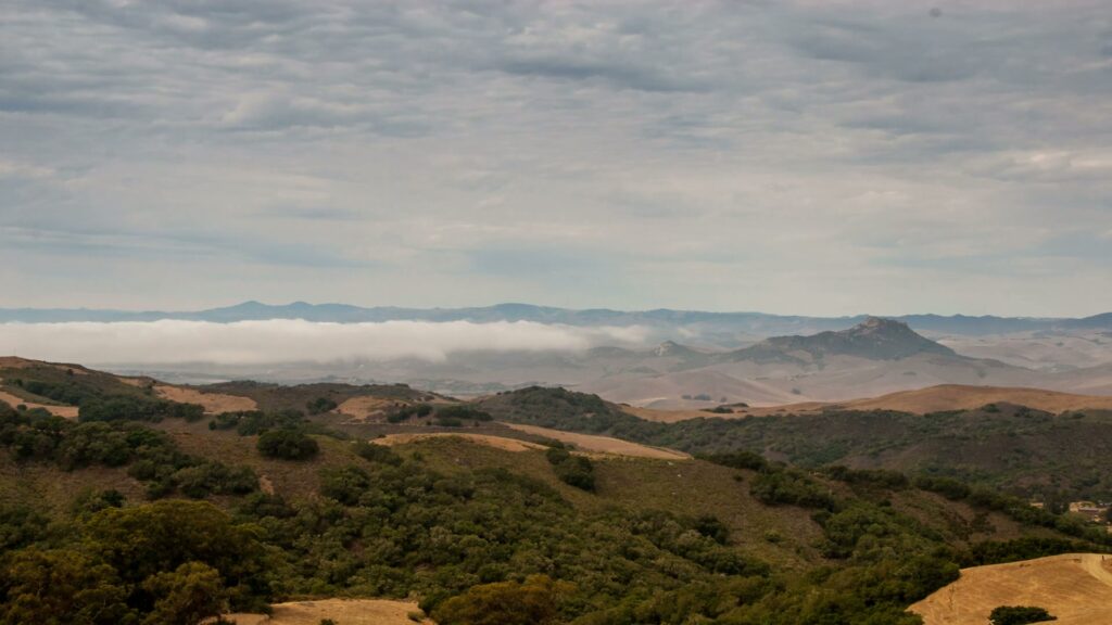 The video depicts a scenic time-lapse landscape with rolling hills stretching into the distance.