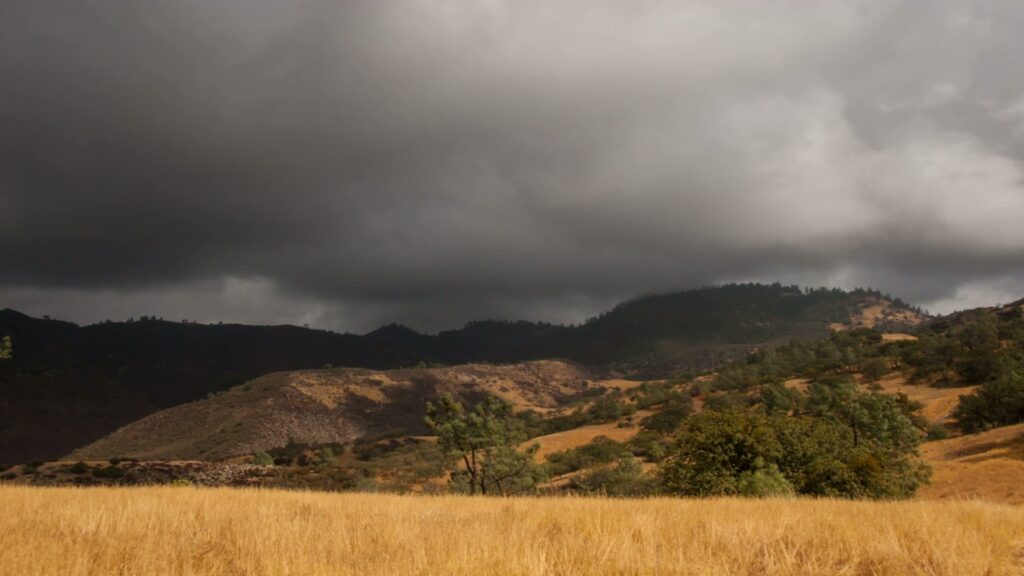 Approaching time-lapse storm over grassy hills