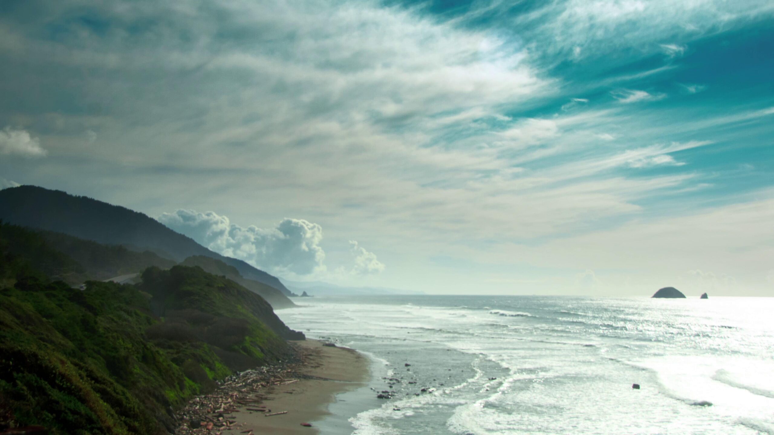 4K video of a serene coastline with time-lapse clouds overhead.
