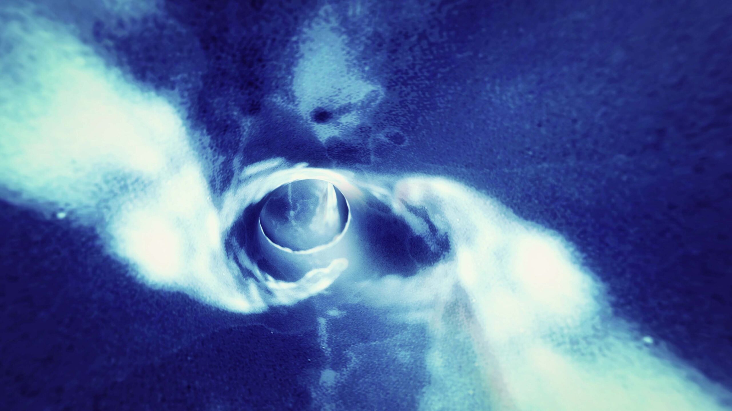 Abstract looping video of a blue and white vortex tunnel with swirling motion and depth.