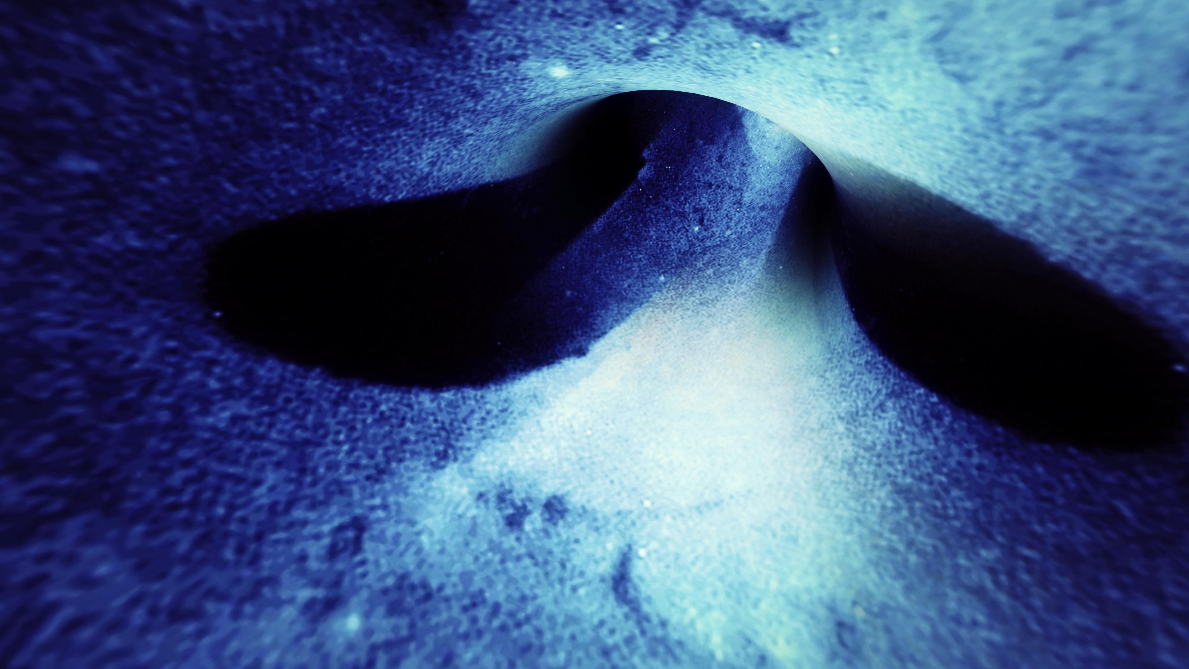 Abstract blue cosmic tunnel with swirling lights leading toward bright white void