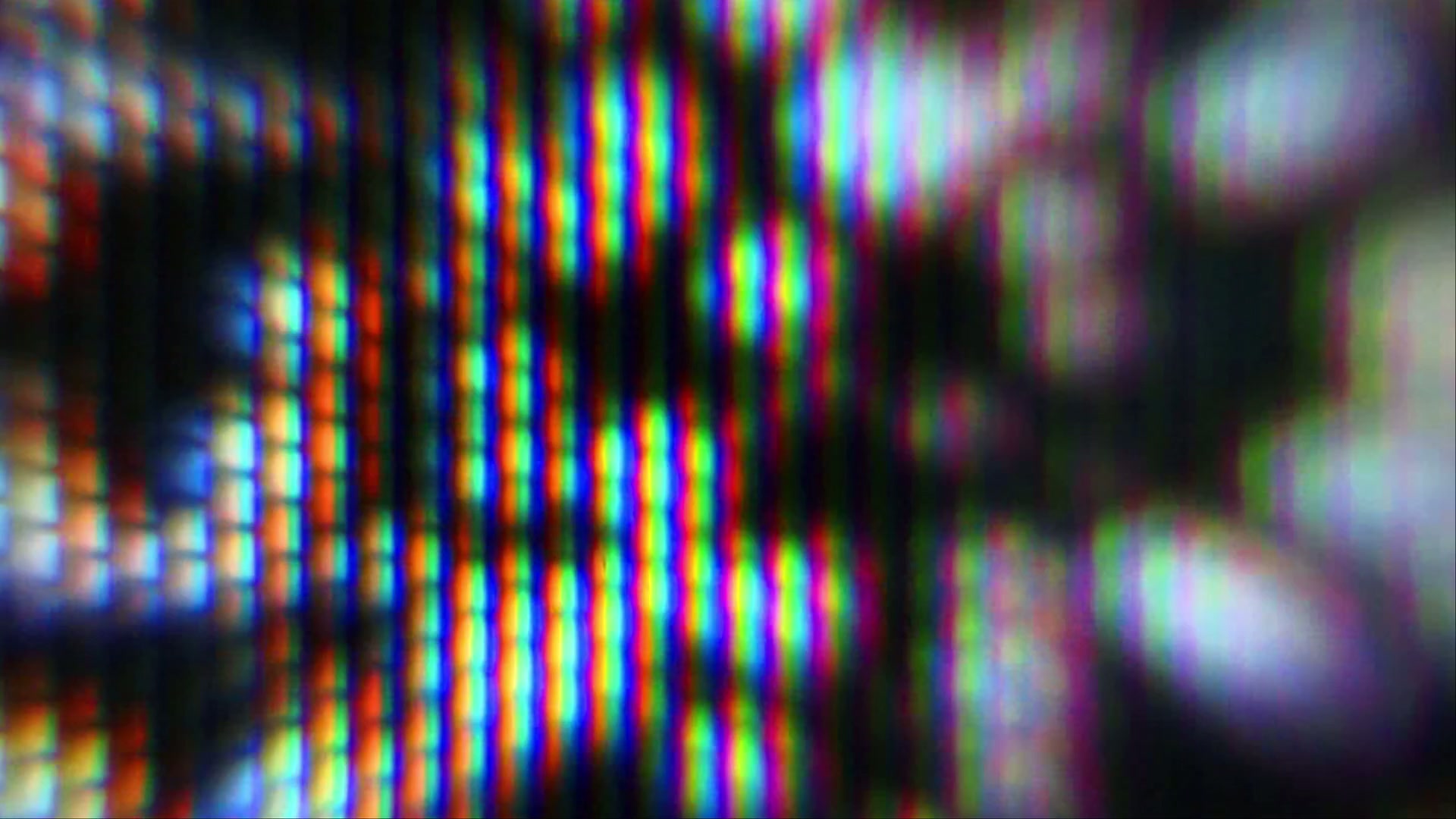Close-up video loop of a colorful, abstract digital screen pattern with strobing RGB subpixels creating a vivid and vibrant kaleidoscopic effect.