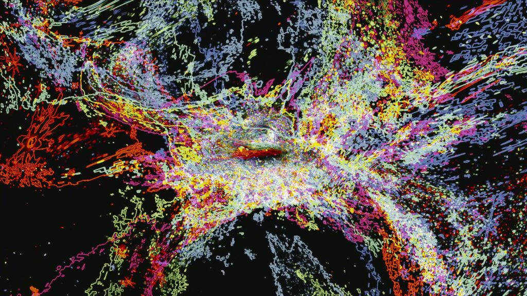 A vibrant abstract video animation explosion of colors resembling a cosmic burst with swirling patterns of red, yellow, purple, pink, and blue on a black background, creating a dynamic and energetic visual effect.