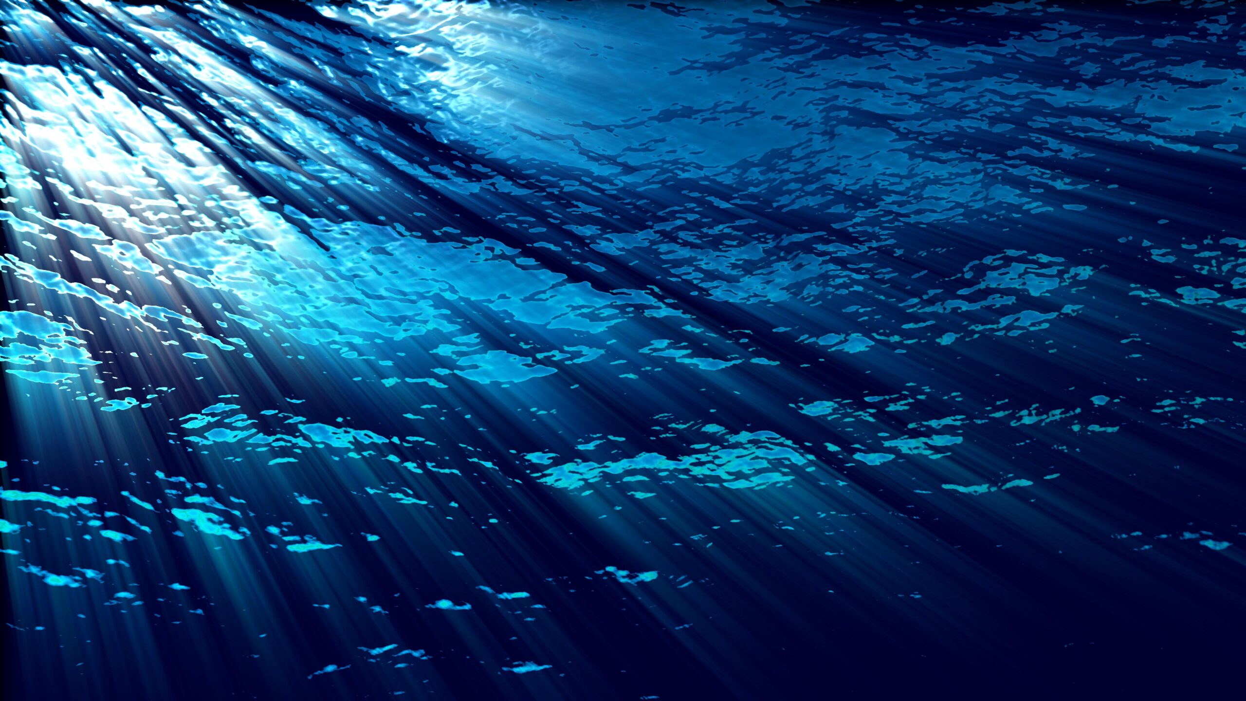 4K video loop of radiant sunrays piercing calm dark-blue ocean waters creating beautiful underwater lighting effects.