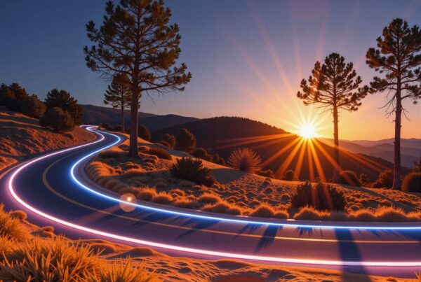 Vibrant sunset with neon-lit winding road amidst silhouetted trees.