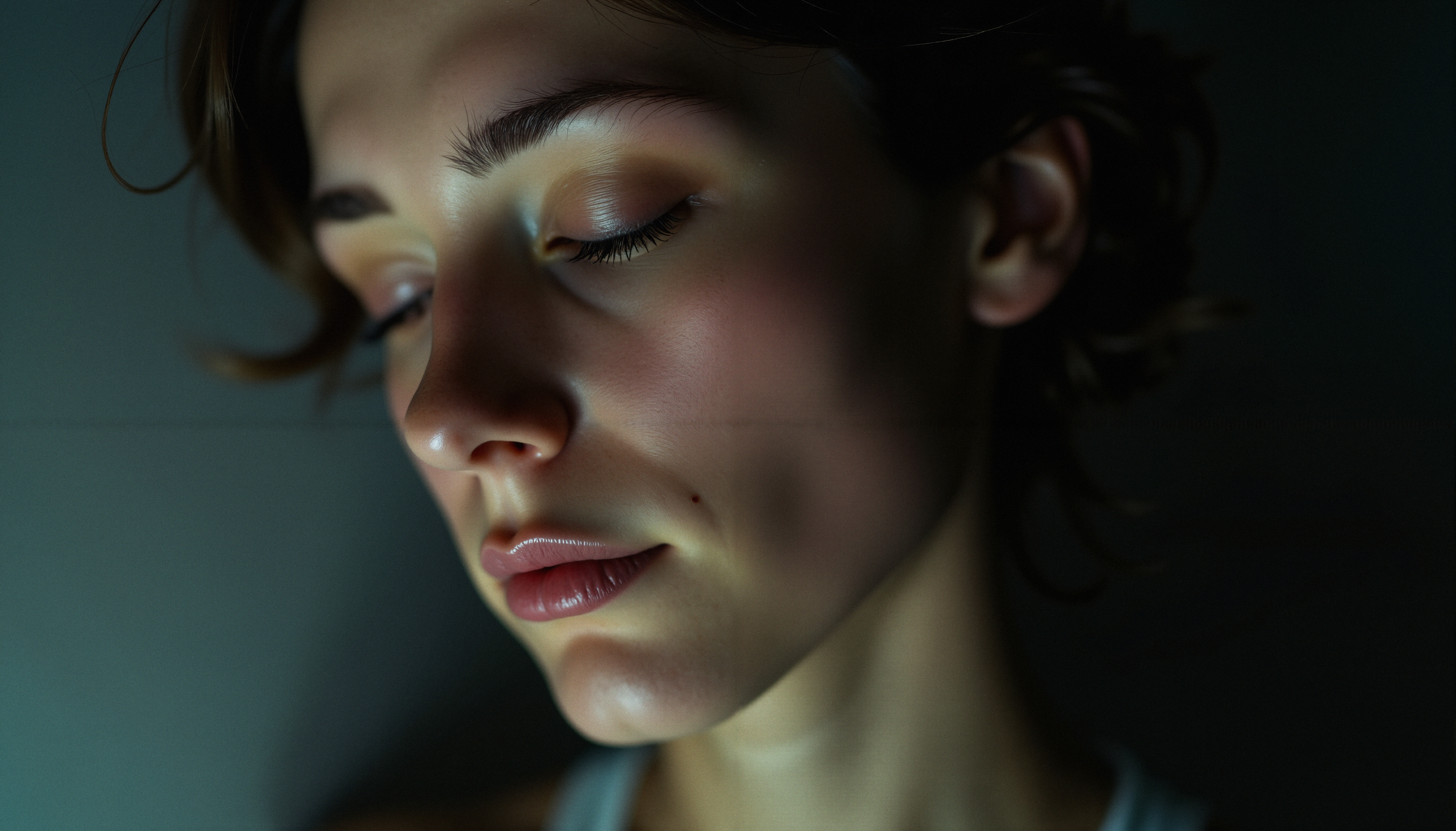 Portrait of a serene person with closed eyes and soft lighting, creating a mood of tranquility and introspection.