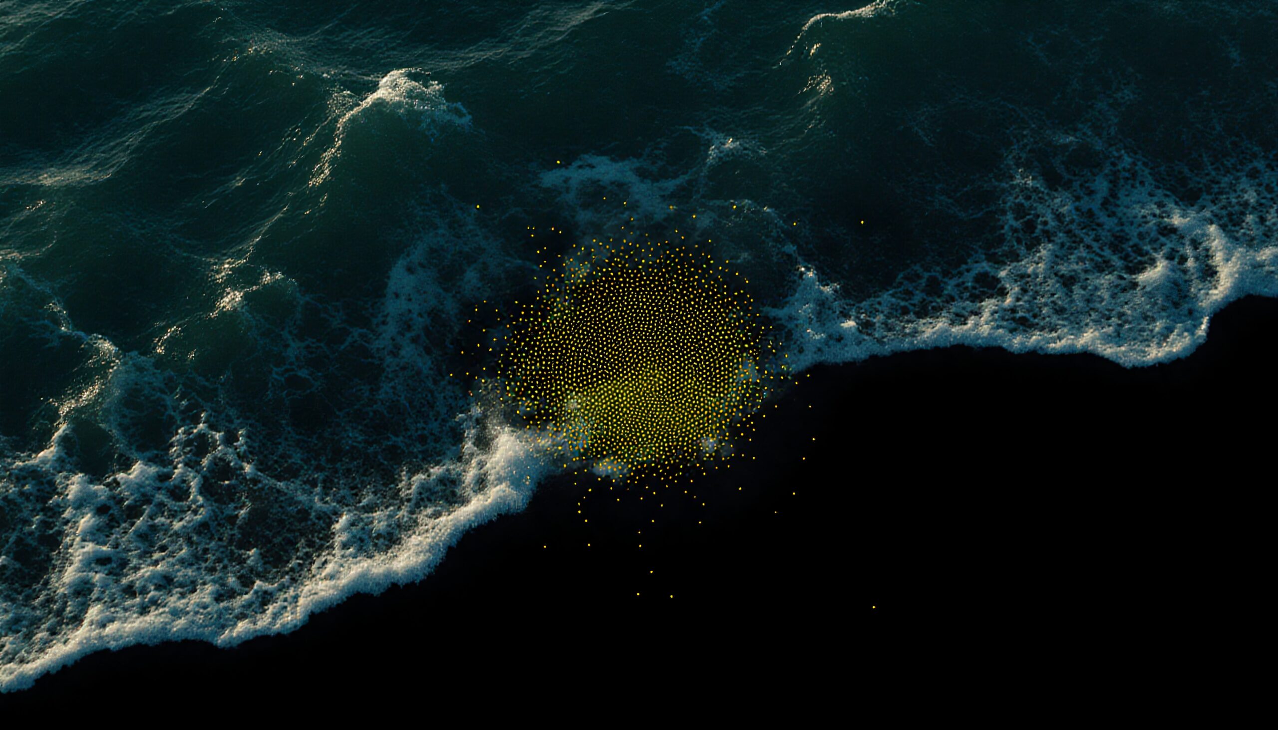 Aerial view of ocean waves over dark water with floating golden dots creating an abstract effect.