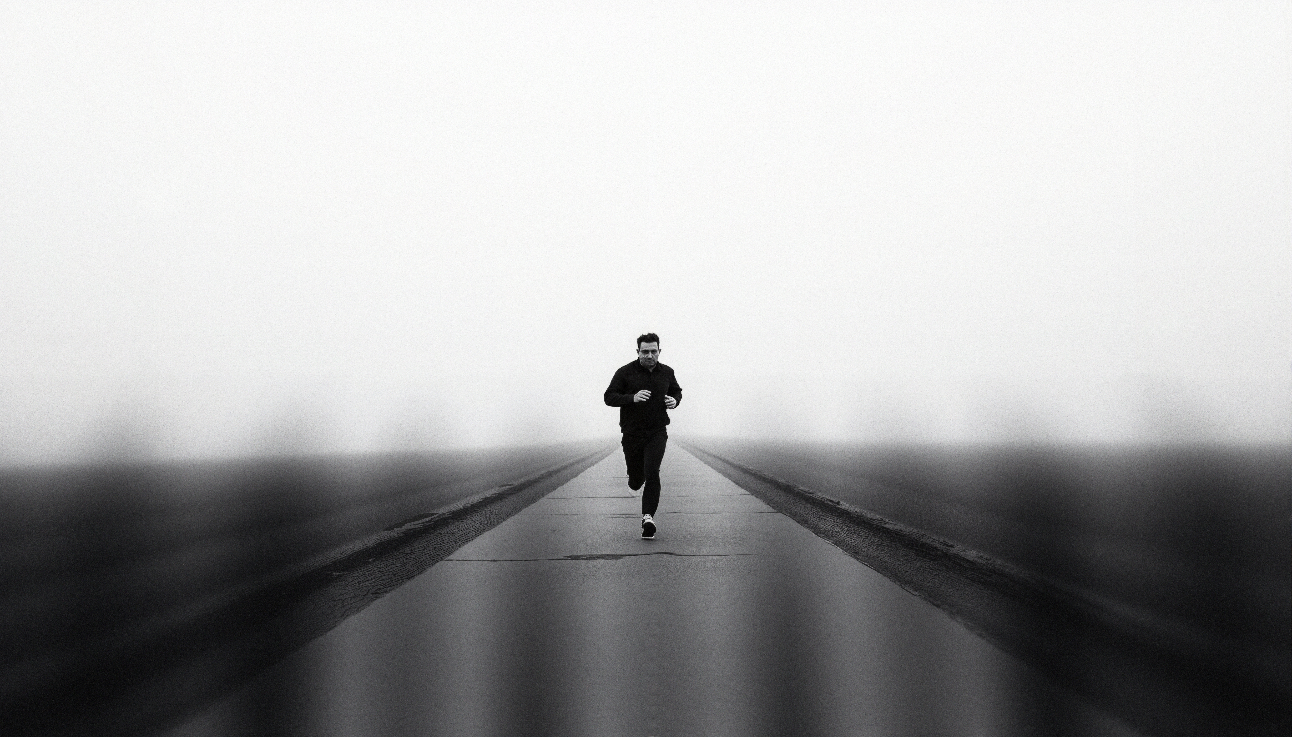 Black and white photo of a runner in the fog.