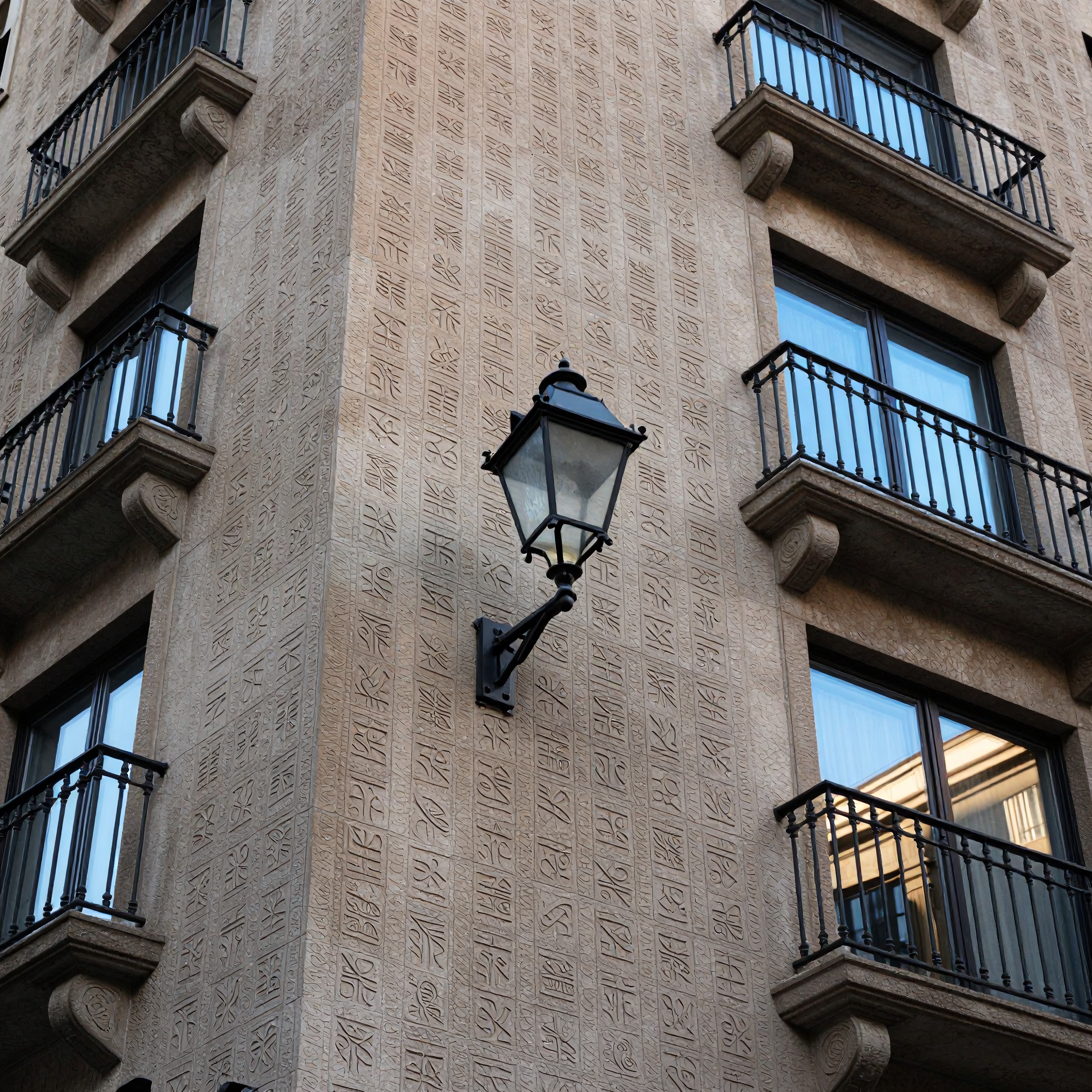 Architectural facade with decorative patterns and lamp.