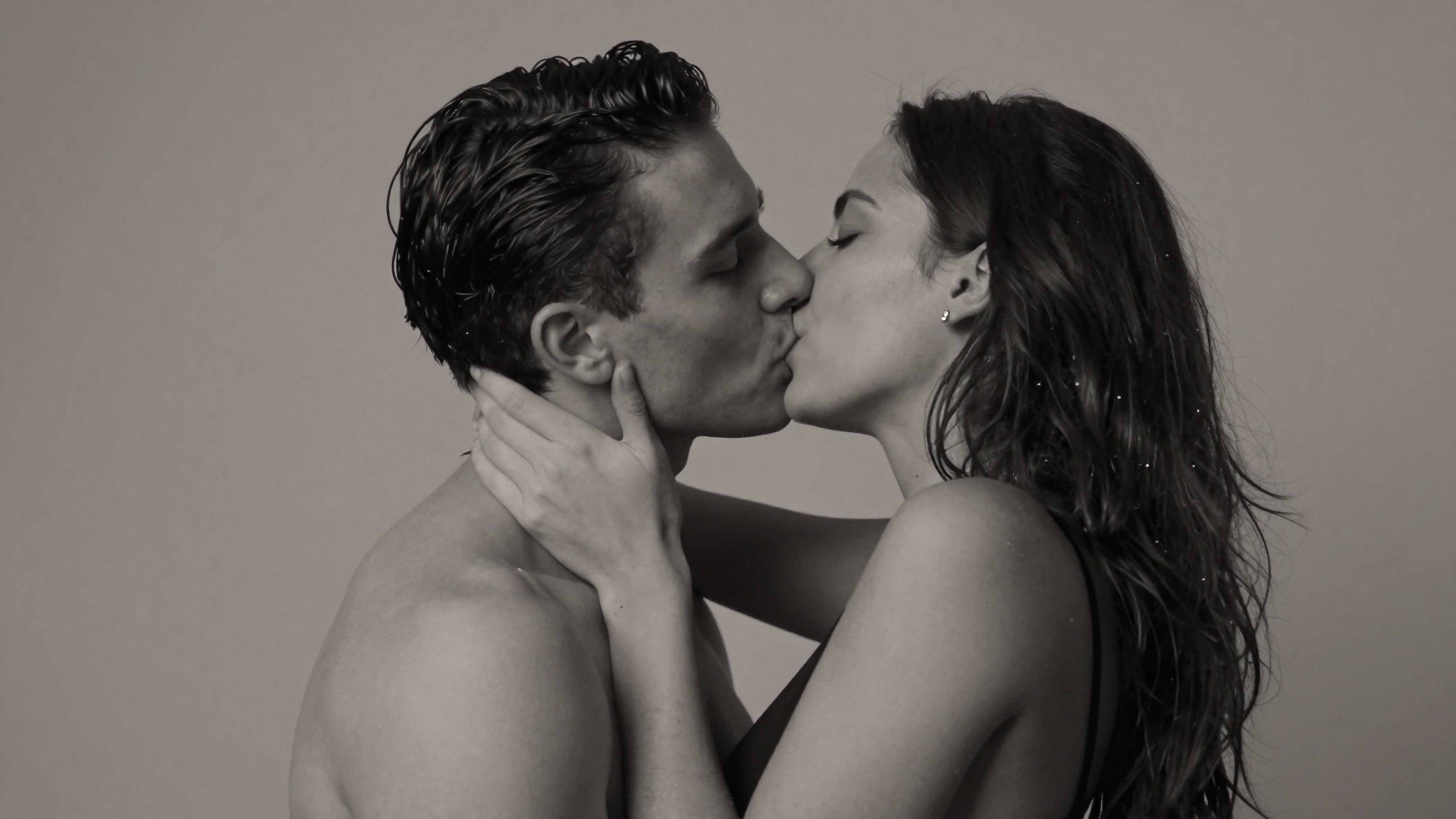 A romantic black and white photo of a couple kissing.