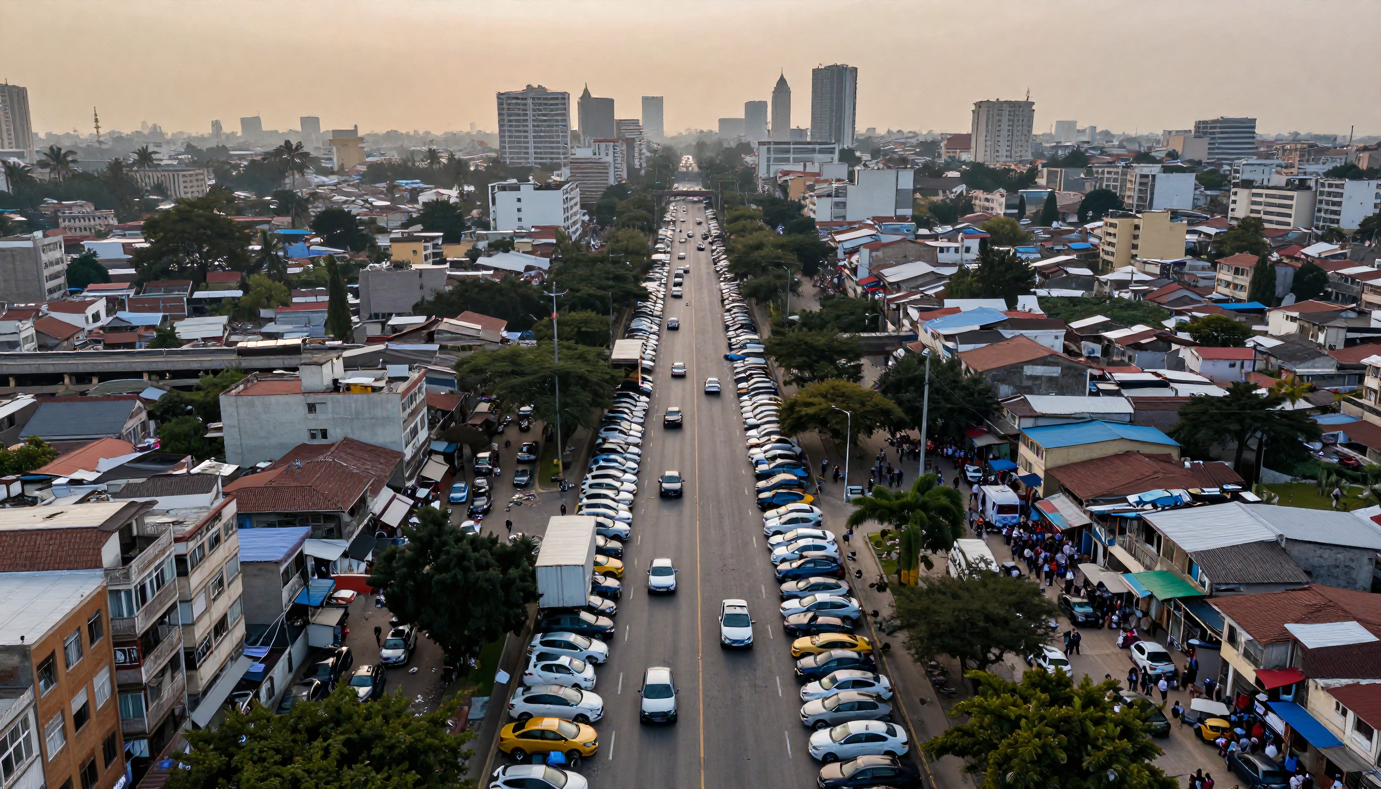 Aerial view of an urban street lined with parked cars, surrounded by buildings, palm trees, and bustling city life at sunset.