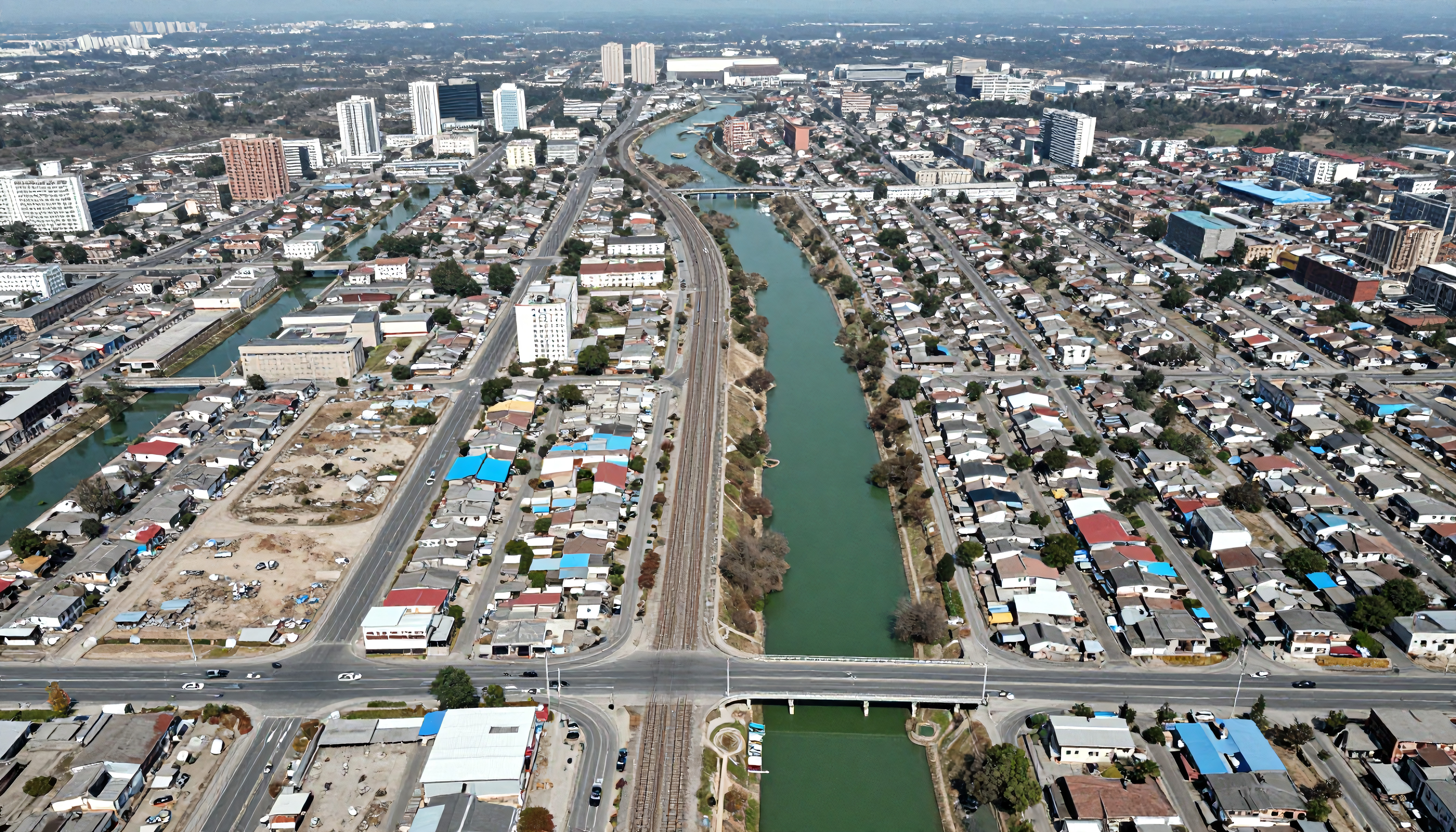 Cityscape with river dividing urban neighborhoods and railway lines