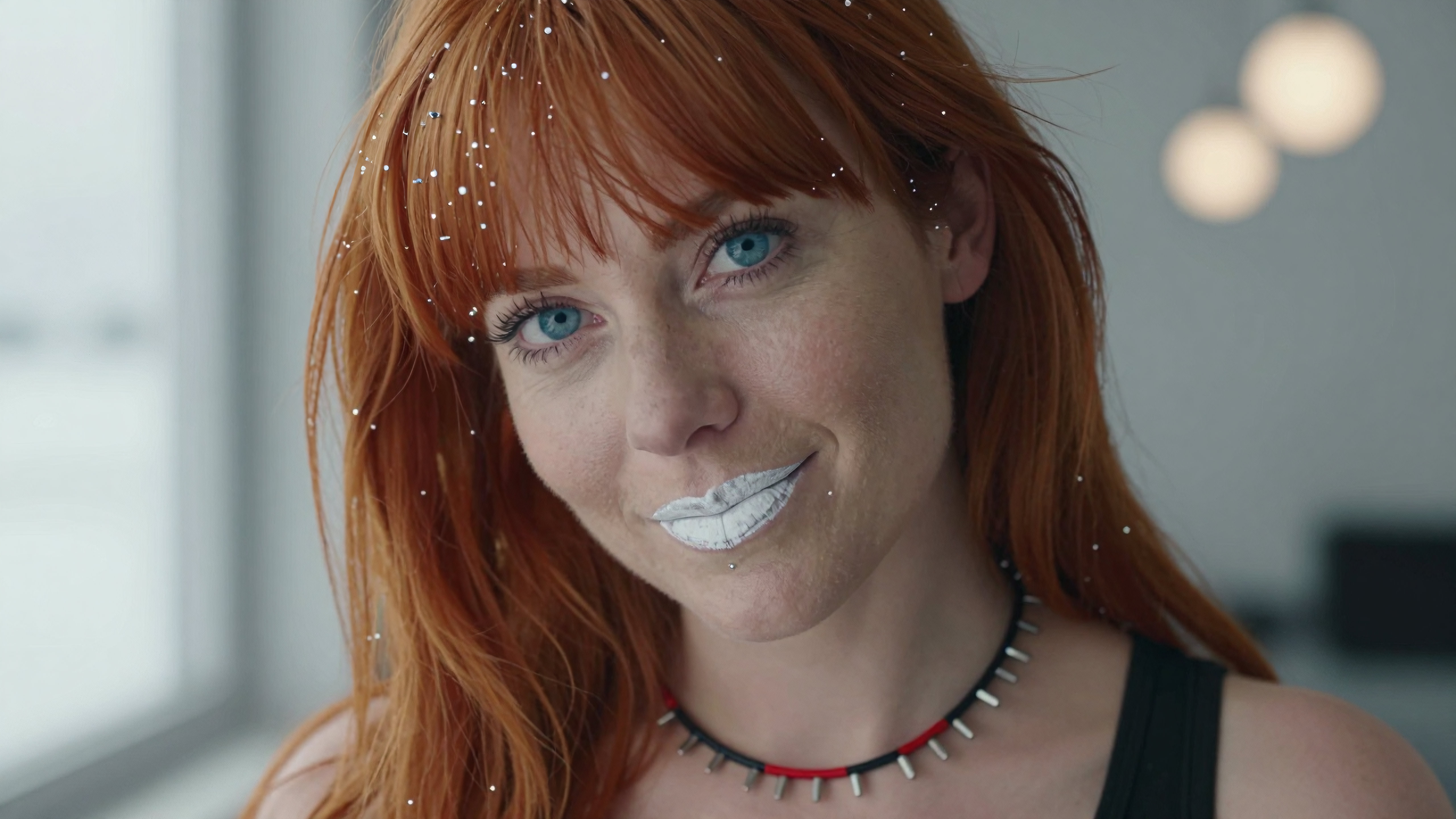 Woman with red hair wearing sparkling glitter and white lipstick posing for glamorous portrait photo