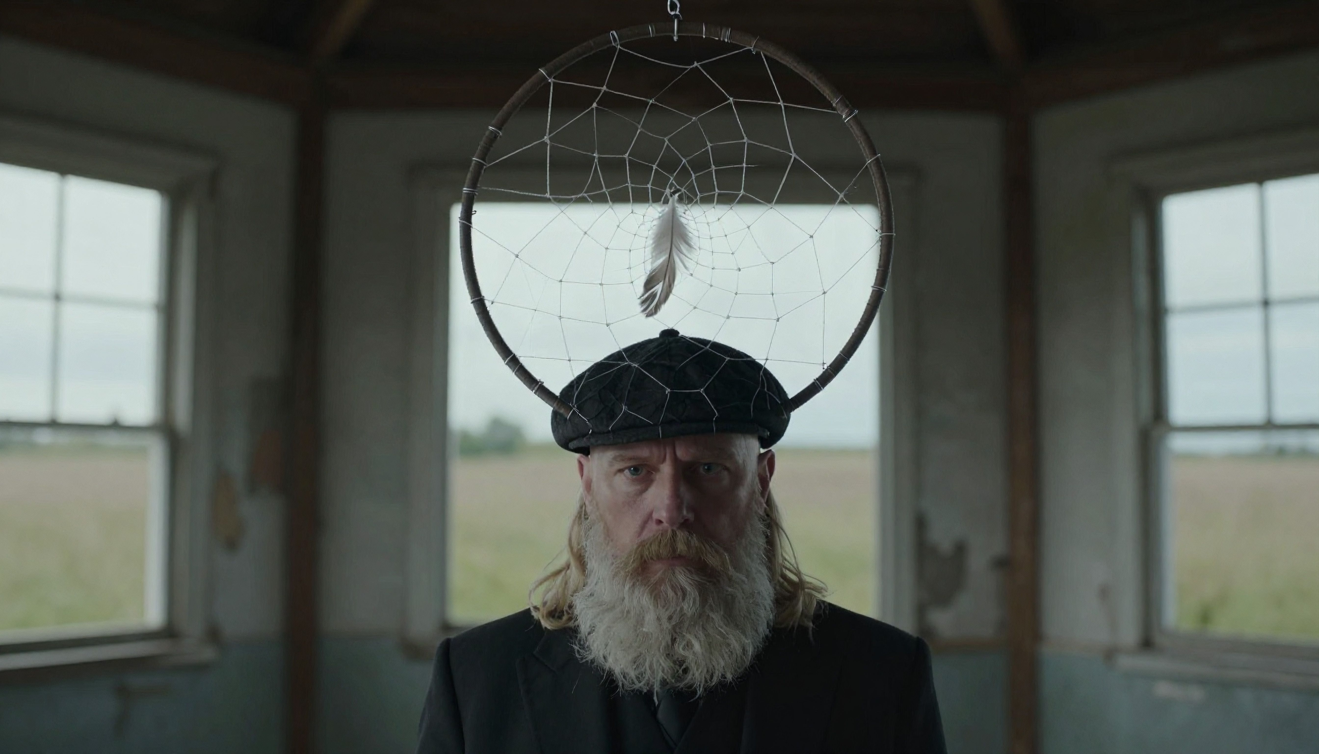 Man with Dreamcatcher and Long Beard in Abandoned Rustic Buildin