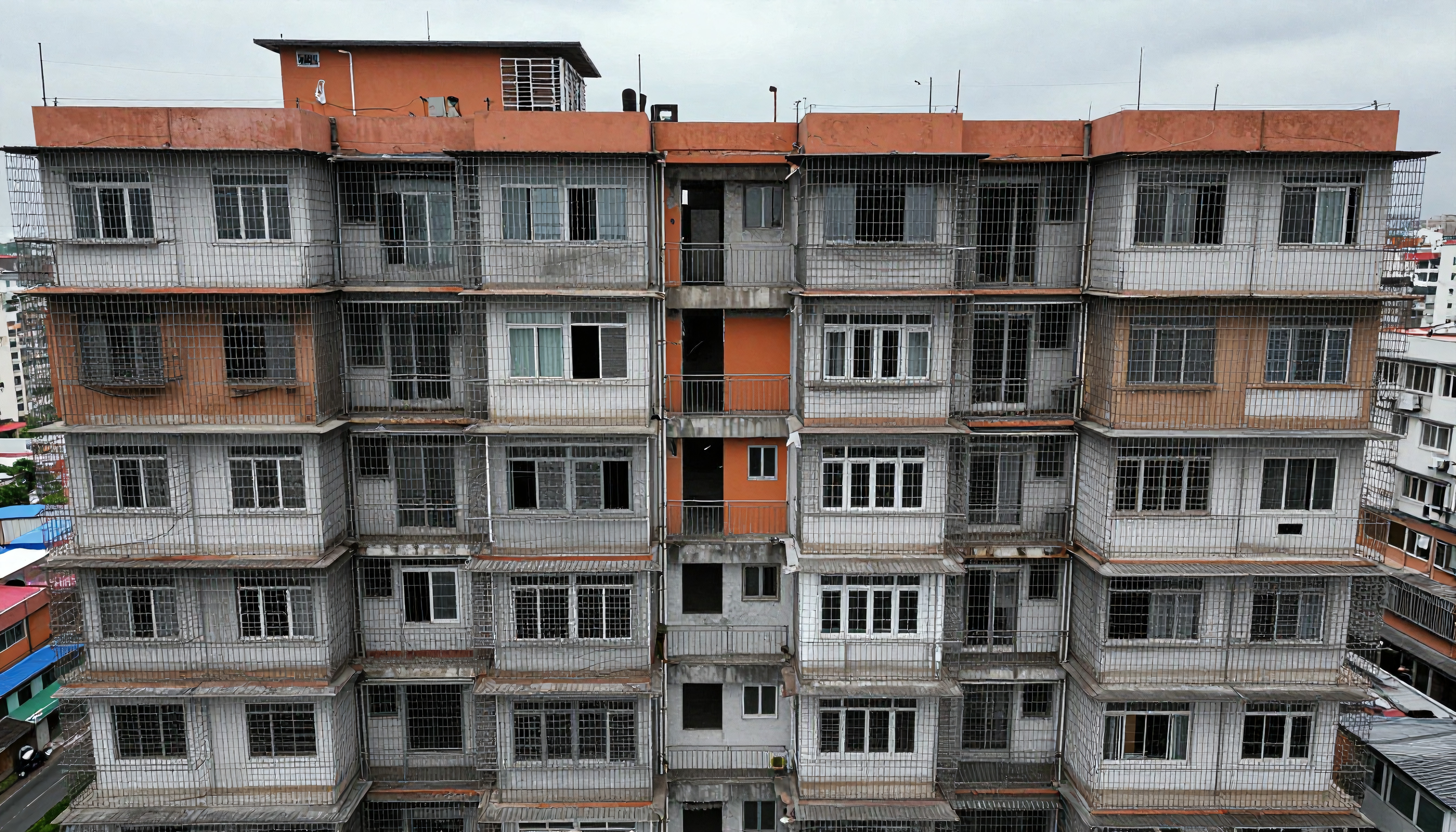 A residential building with barred windows, displaying urban architectural resilience.